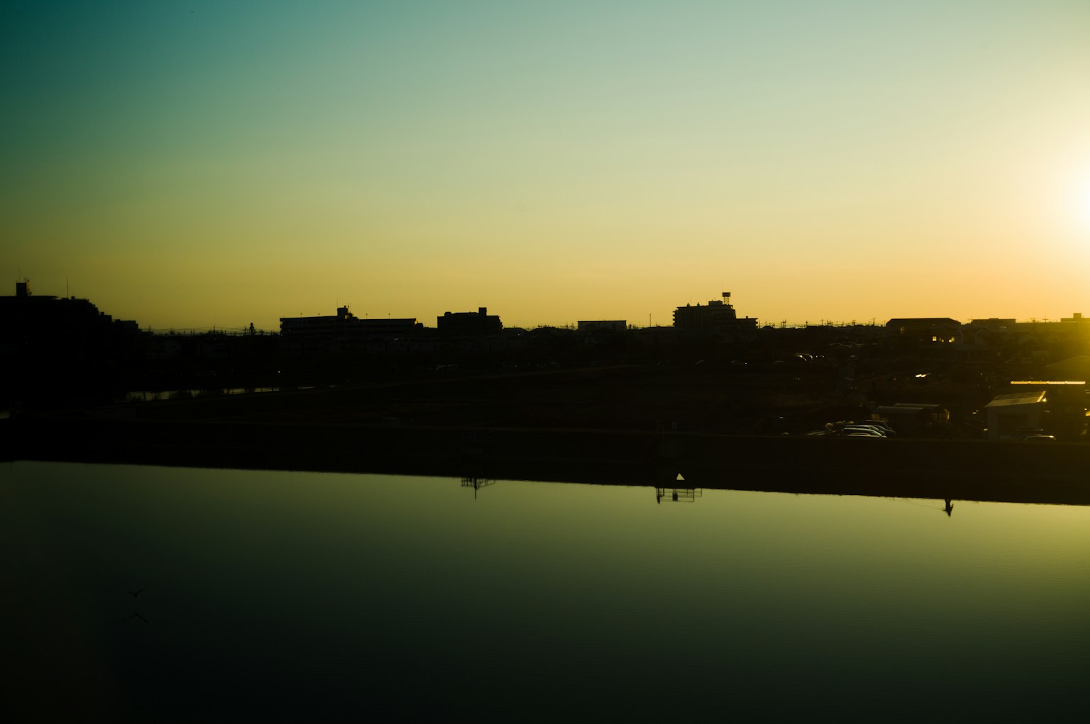 Silhouette of a city at sunset with reflections