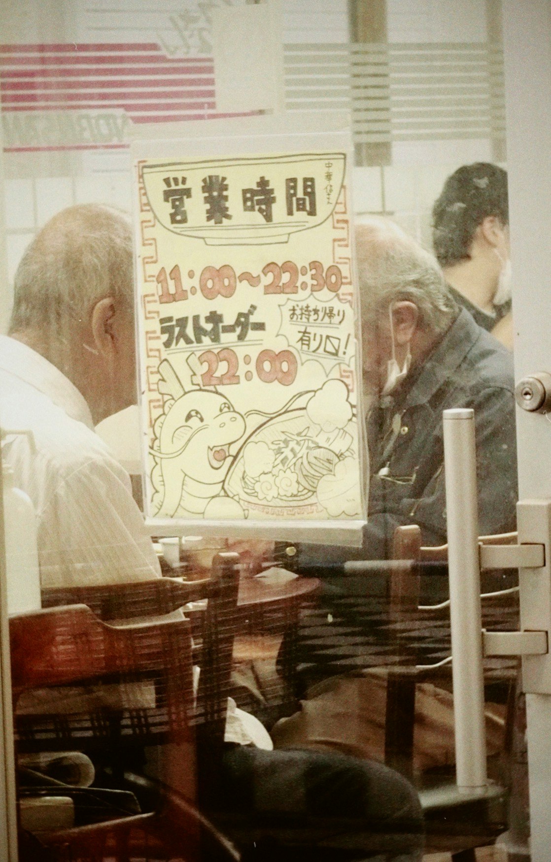 店内のカウンター越しに掲示された営業時間とキャラクターの案内画像