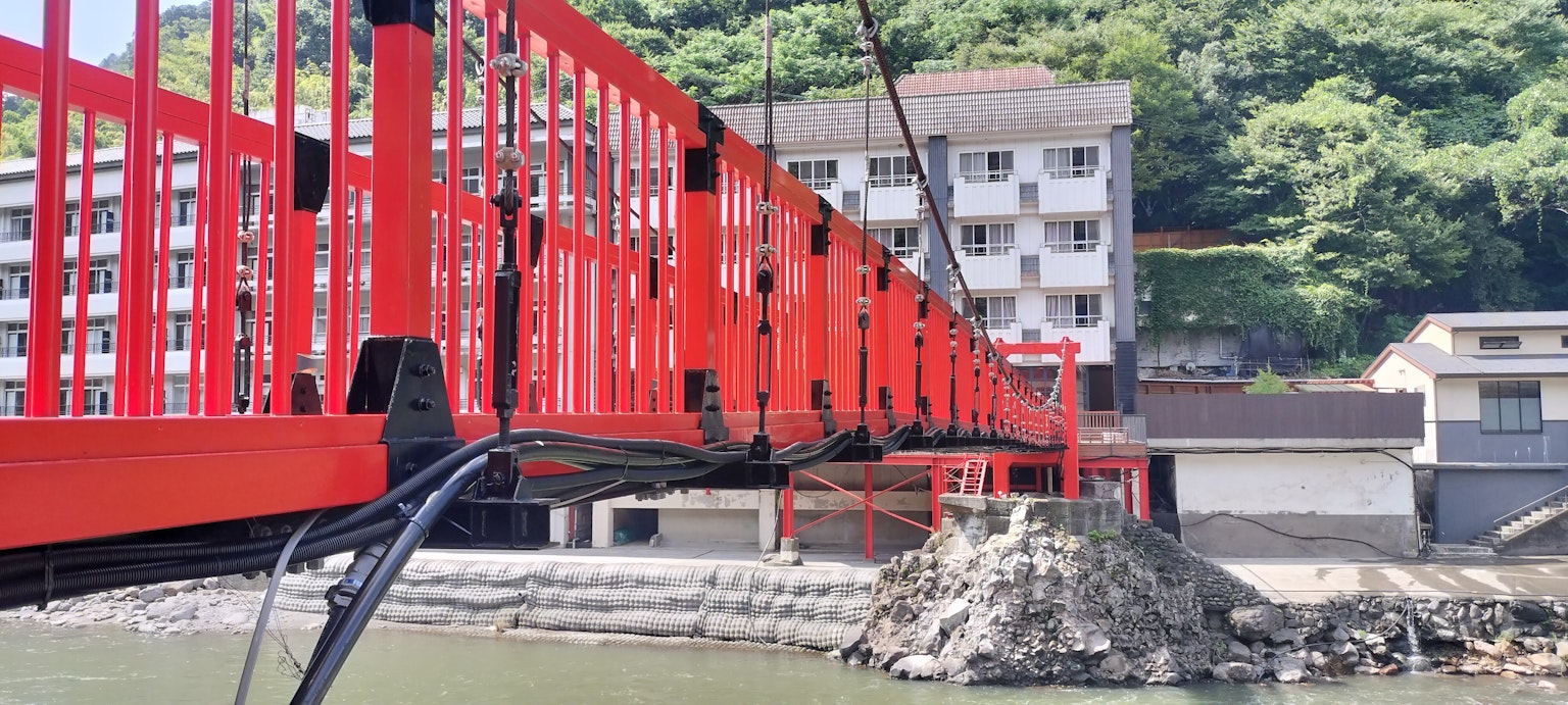 Ponte sospeso rosso con edifici sullo sfondo