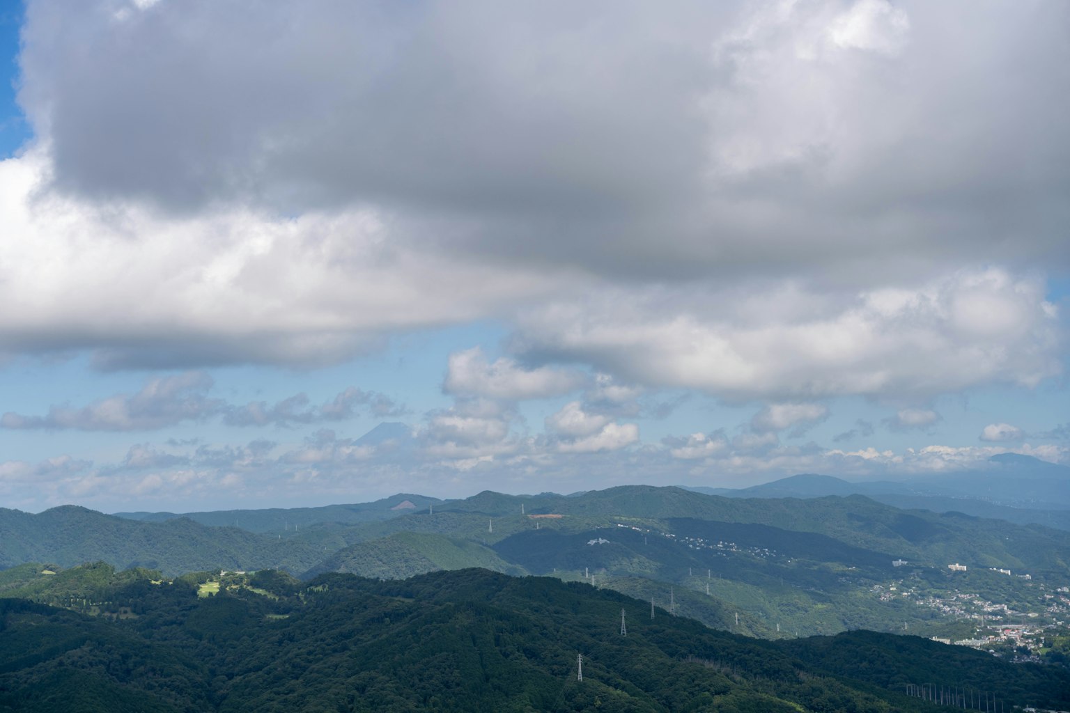 Pemandangan panorama pegunungan di bawah langit biru dengan awan