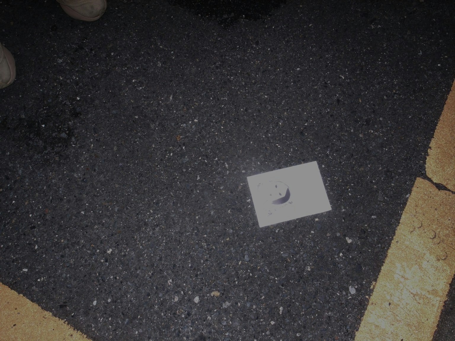 Scena con una carta bianca e un piccolo pezzo di metallo su una superficie scura