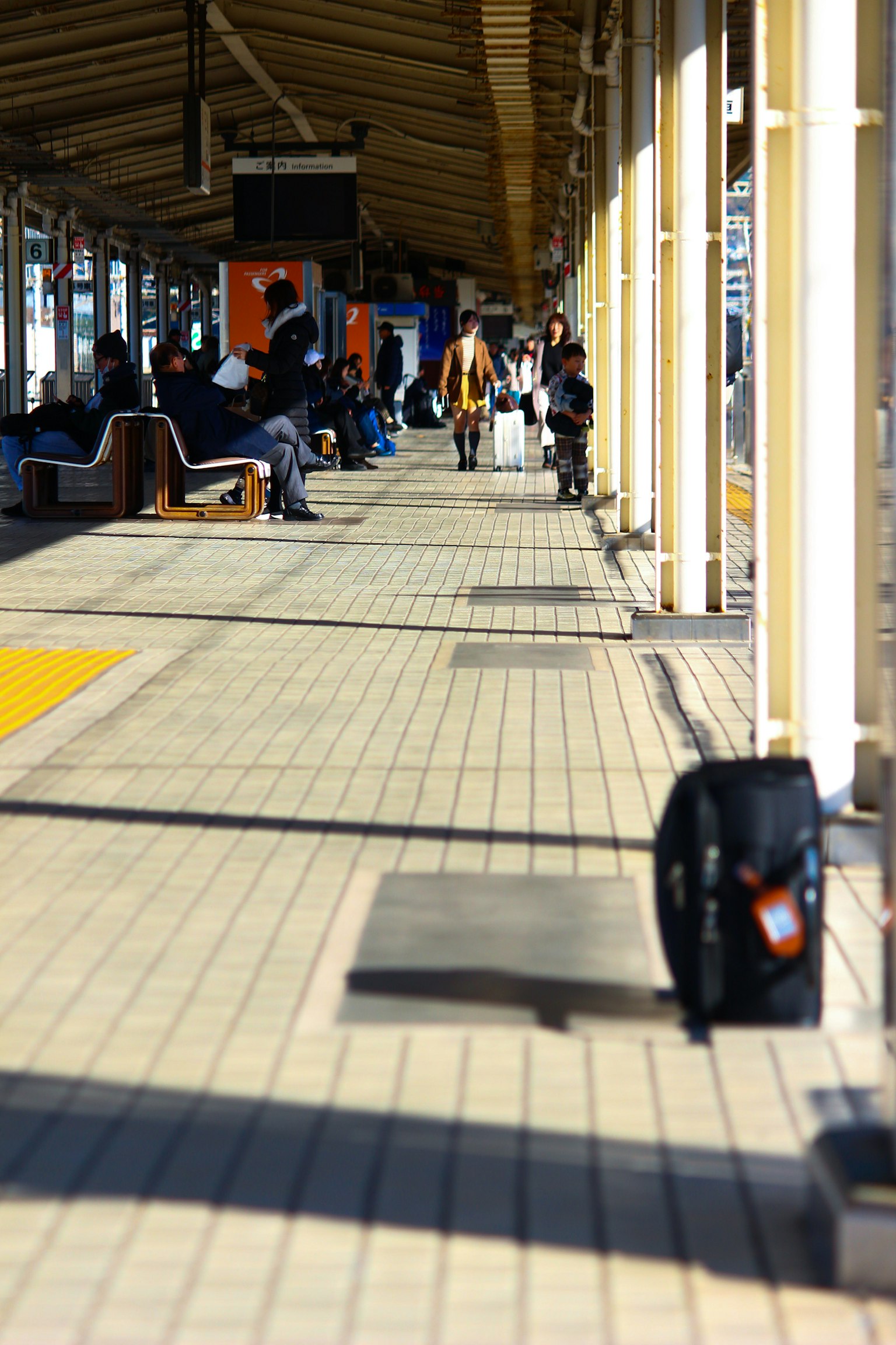 駅のプラットフォームにいる人々と荷物