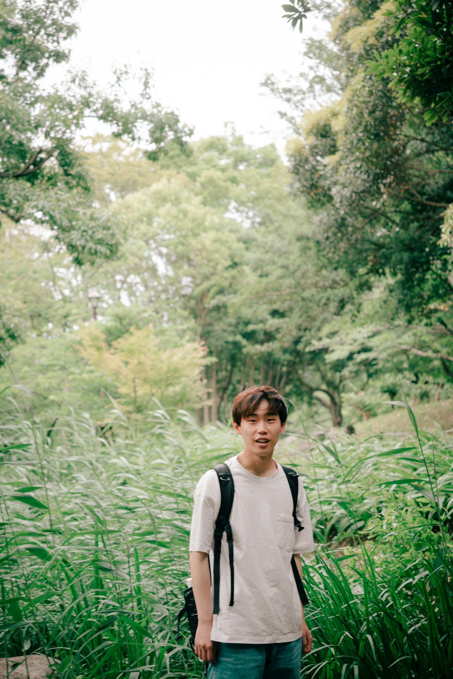 一名年轻男子站在郁郁葱葱的草地上