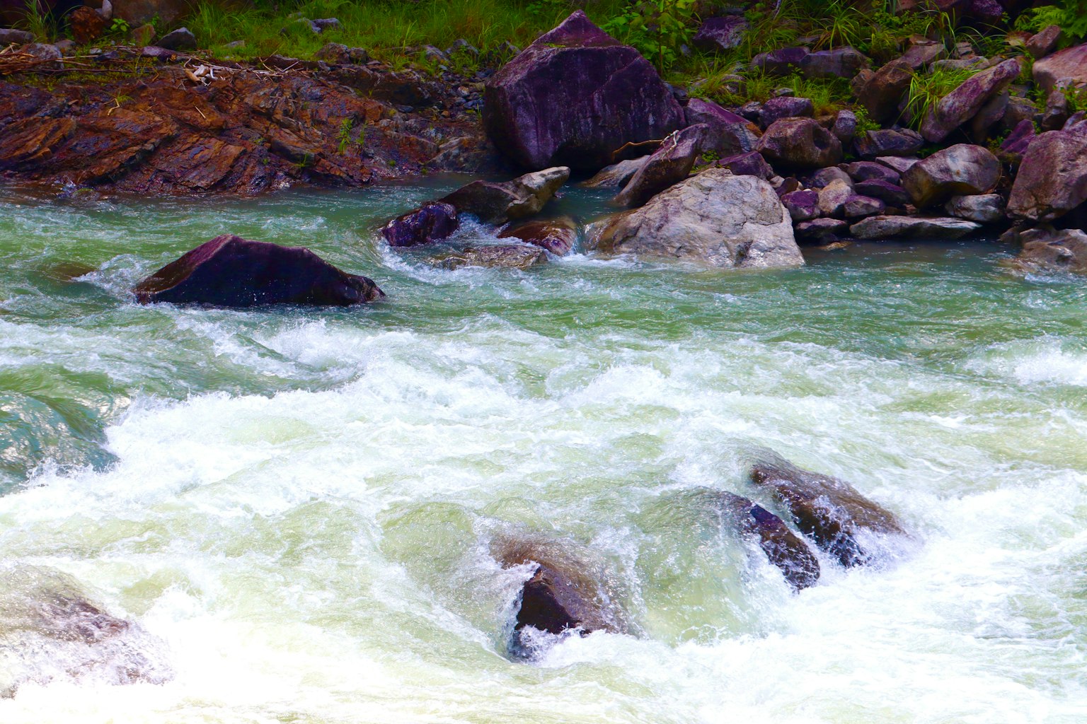 Eau tumultueuse sur de gros rochers dans une rivière