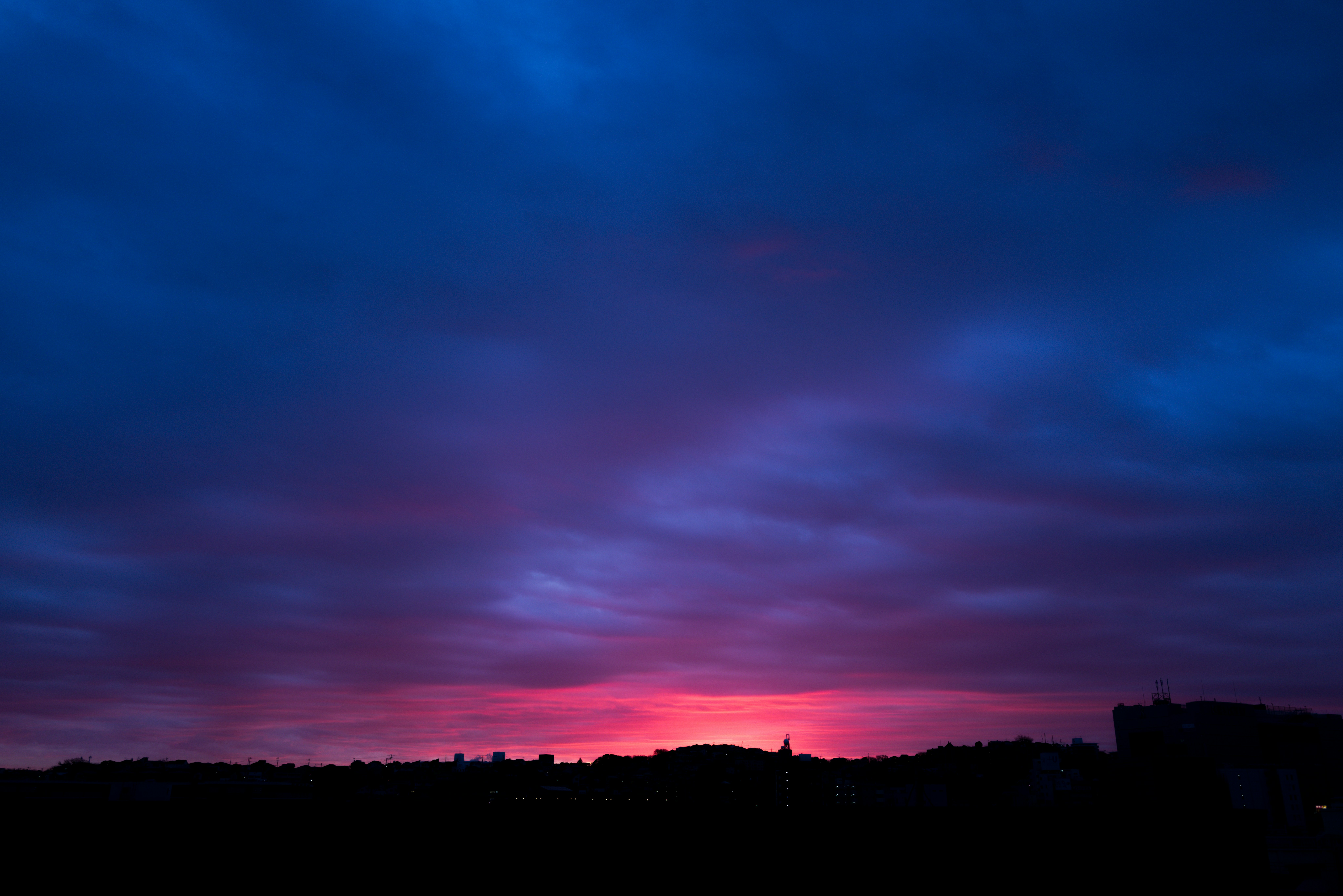 夕焼けの空とシルエットの街並み