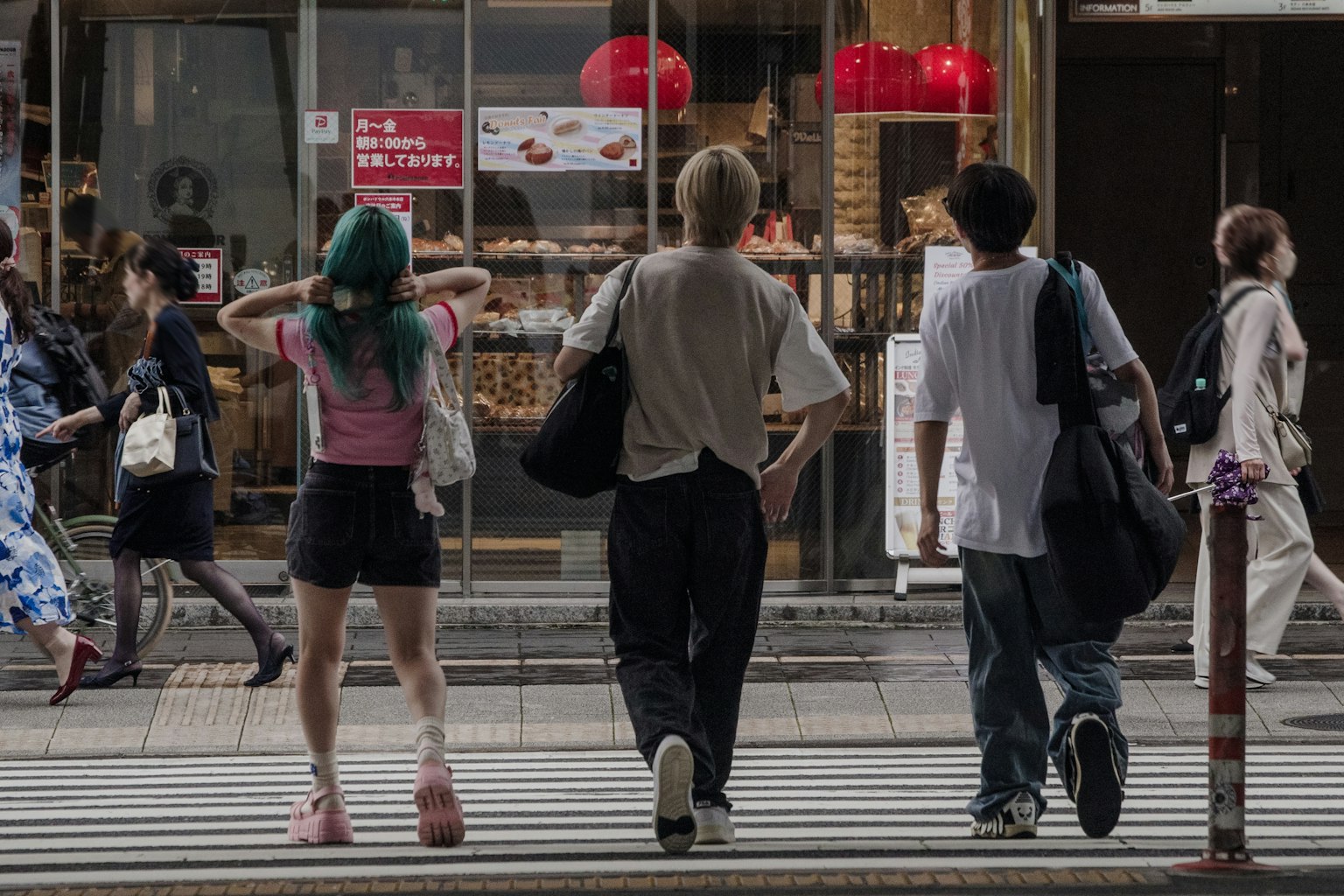Escena de personas cruzando la calle Una mujer con cabello verde y dos hombres caminando juntos