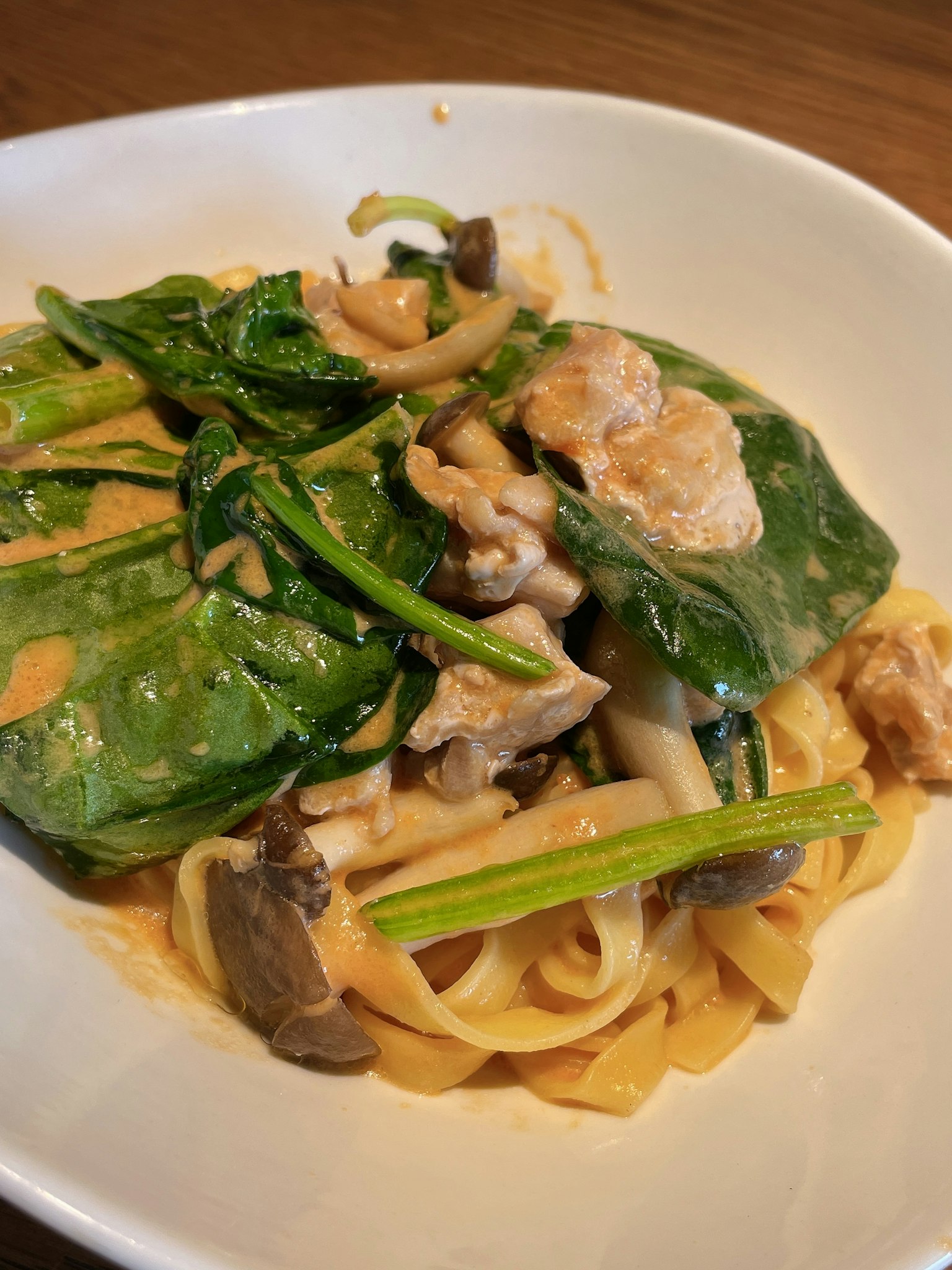Pasta mit cremiger Sauce, garniert mit Spinat und Pilzen