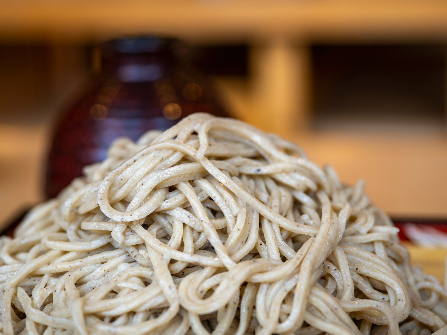 Ein Haufen Soba-Nudeln mit einer braunen Keramiksoße