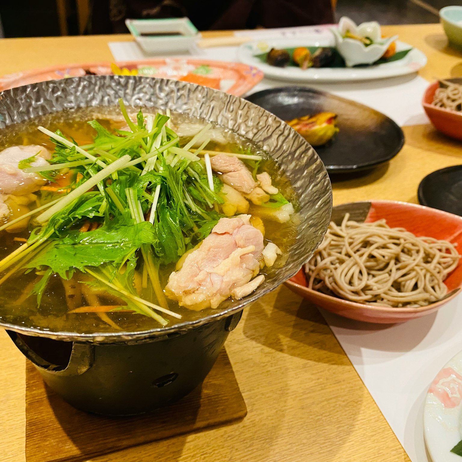 Meja makan Jepang dengan hot pot dan mie soba