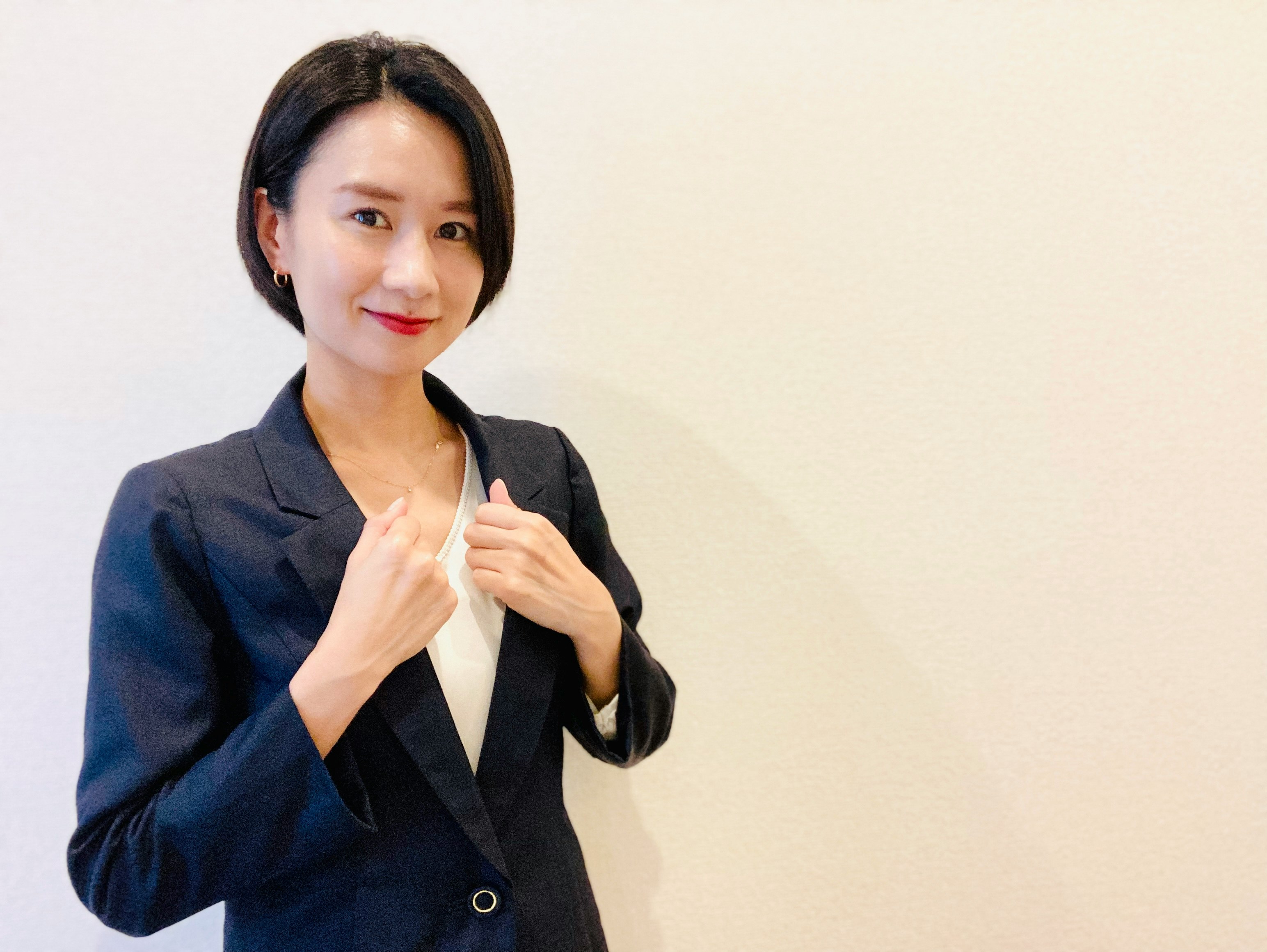 白色背景下微笑的西裝女性擺姿勢