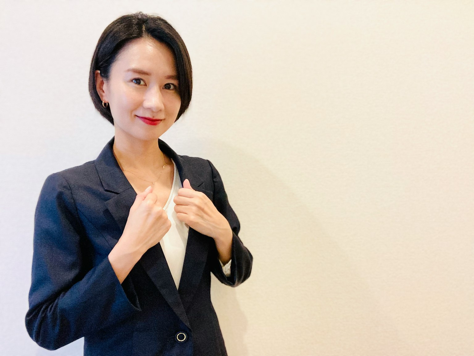 一位身穿西装的女性微笑并摆姿势