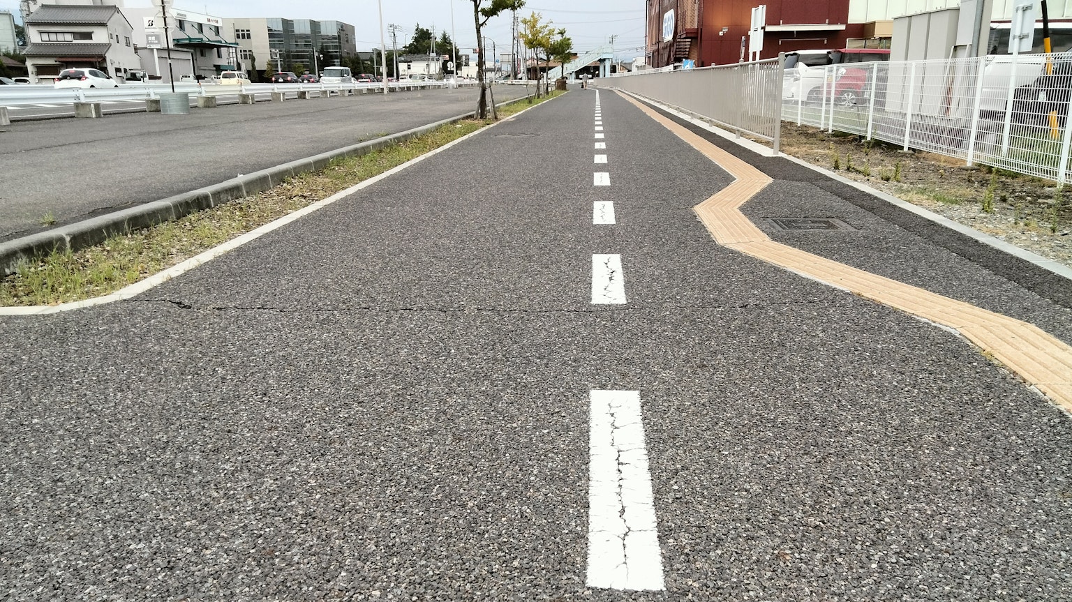 Camino pavimentado con líneas blancas y una marca naranja