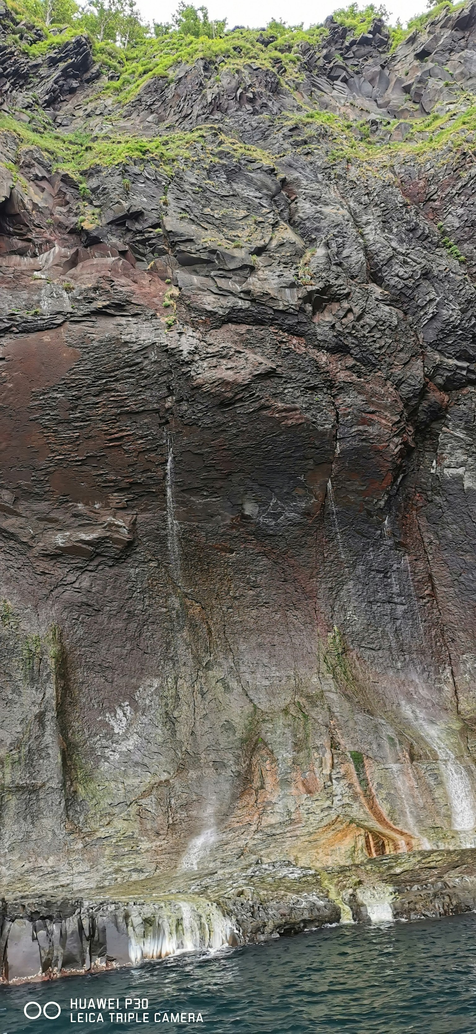 Photo d'une falaise côtière montrant des variations de couleur et des textures
