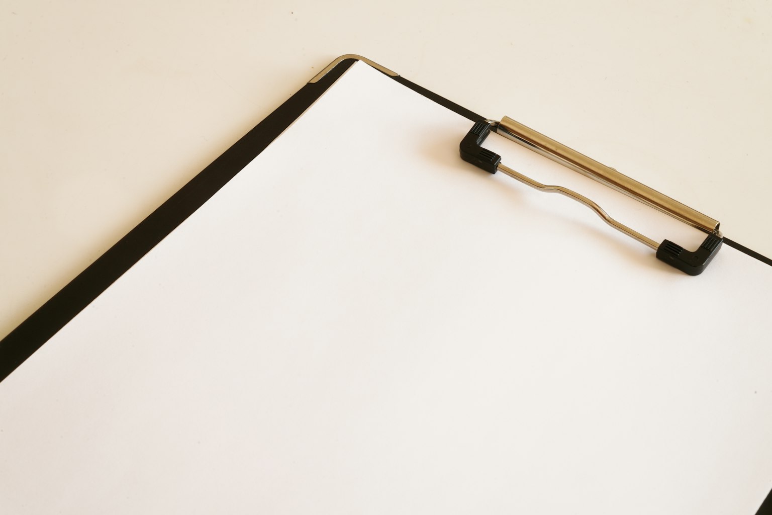 Gambar sederhana clipboard dengan selembar kertas putih di atasnya