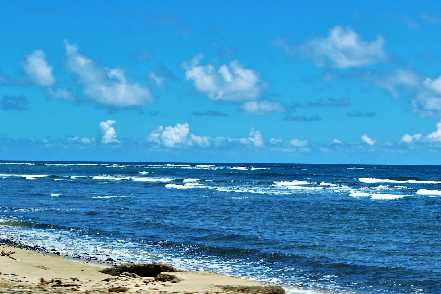 Schöne Strandlandschaft mit blauem Ozean und weißen Wolken