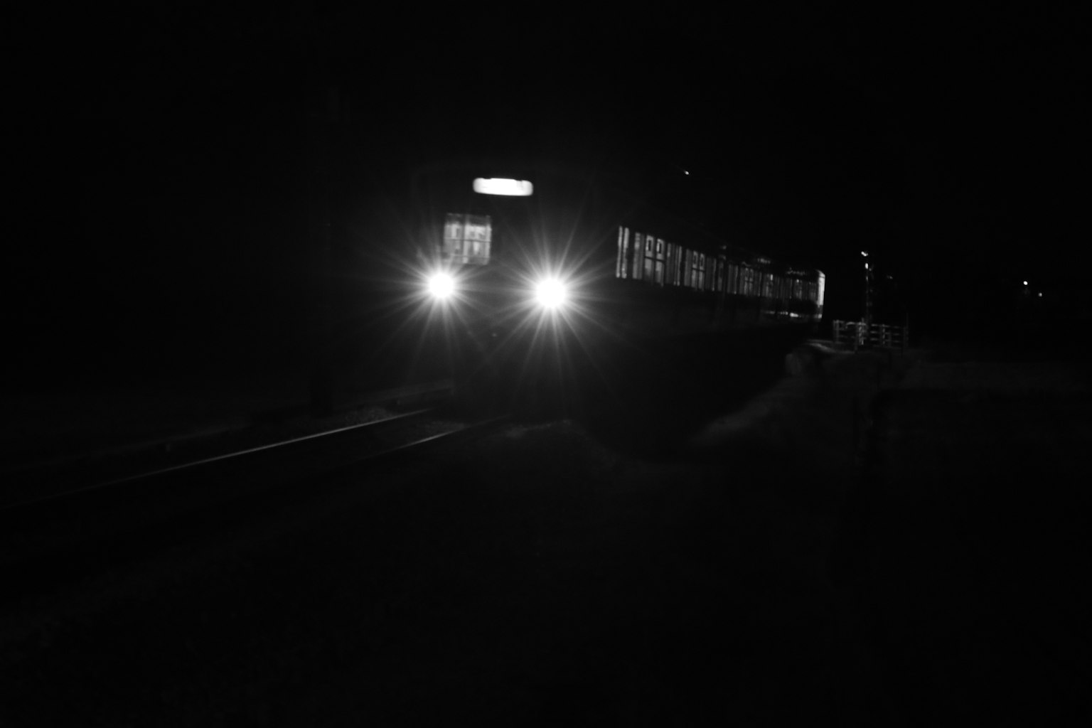 Treno in avvicinamento con fari luminosi nel buio
