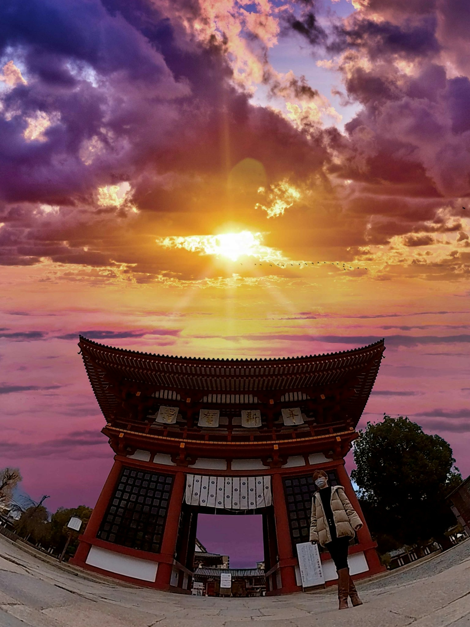 传统日本门与壮观的日落和五彩缤纷的云彩