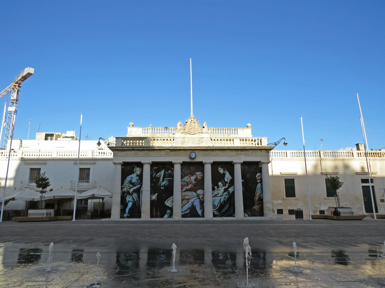 Edificio blanco con gran arte en la fachada y cielo azul claro