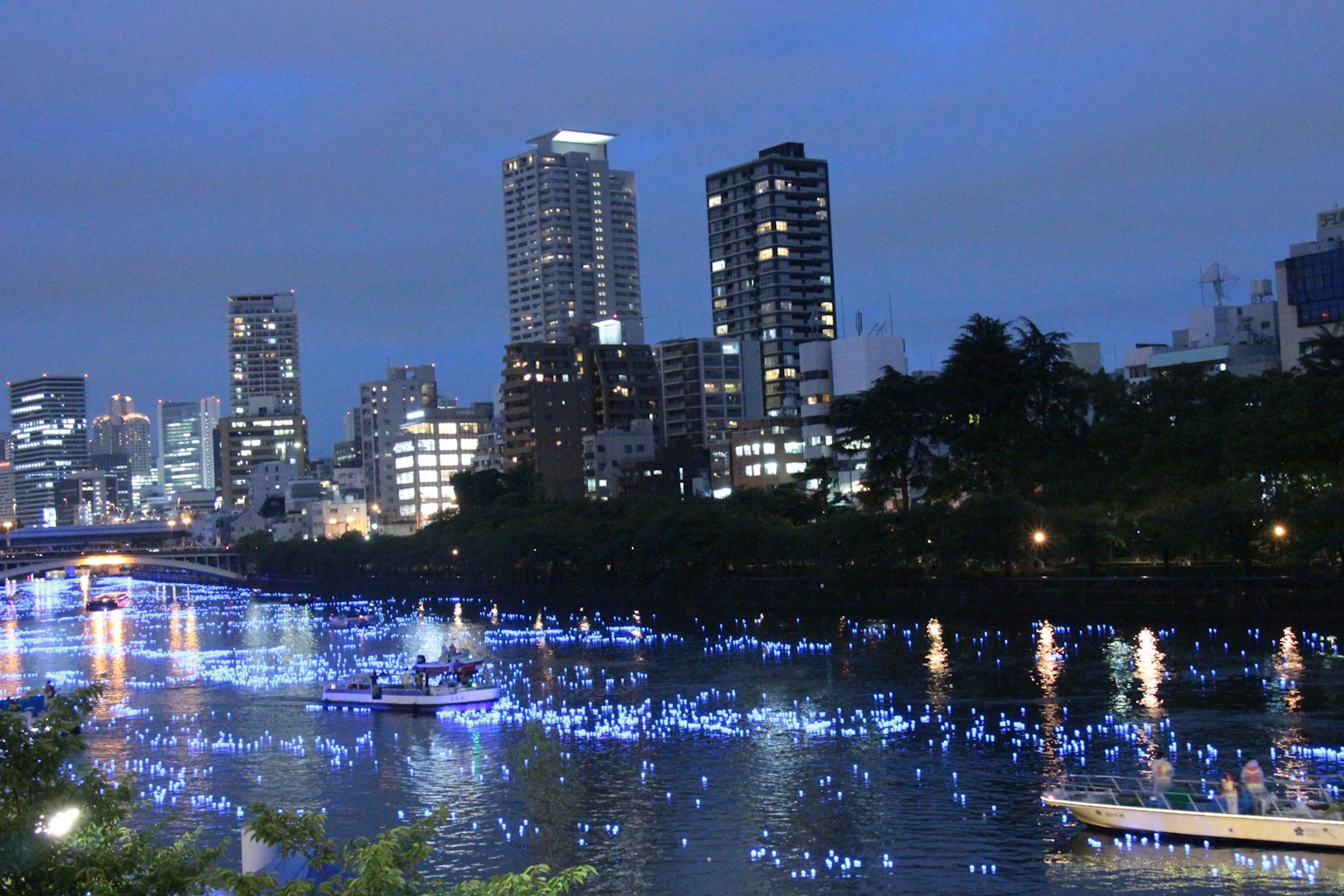 Skyline della città di notte con luci blu che si riflettono sull'acqua