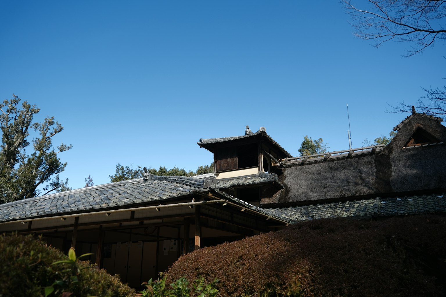 Atap rumah tradisional Jepang di bawah langit biru yang cerah