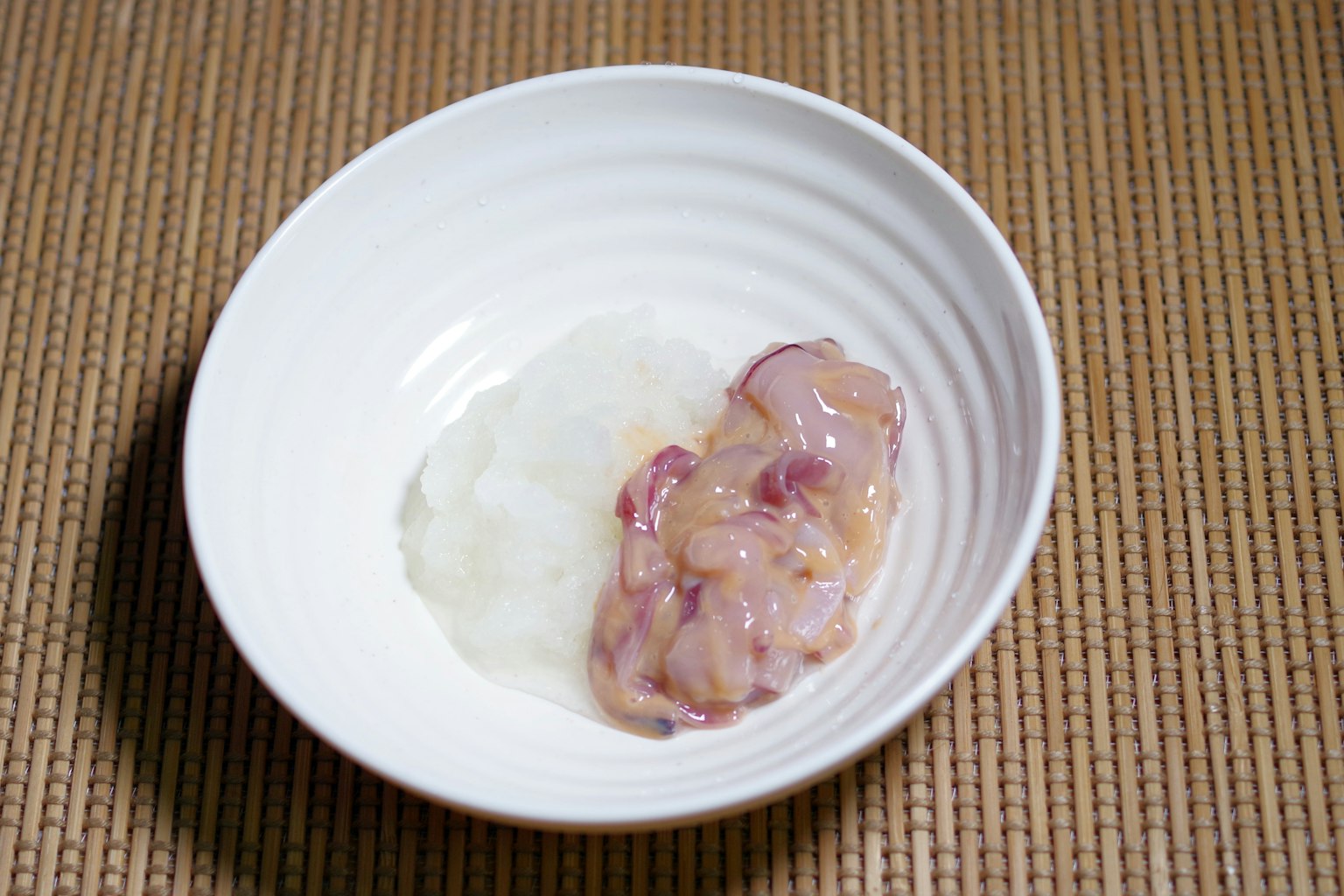 Filetto di pesce crudo servito con riso in una ciotola bianca