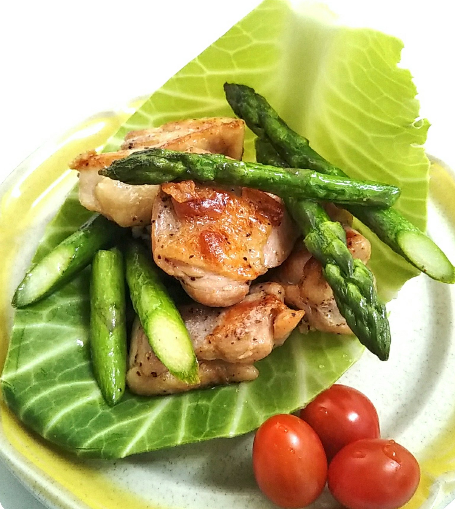 Assiette avec du poulet grillé, des asperges et des tomates cerises