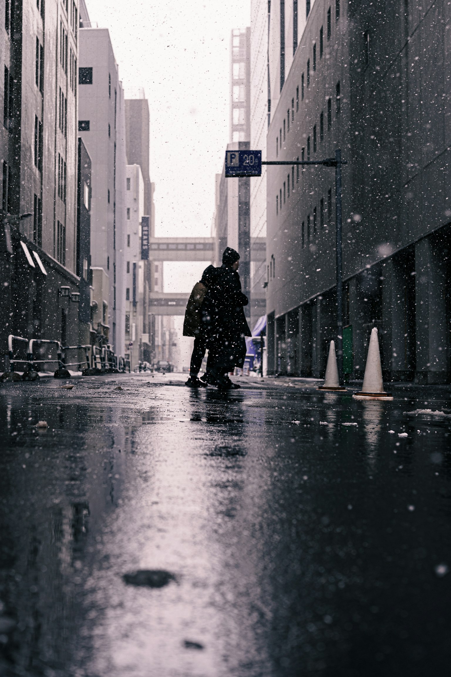 兩個人在雪天的城市街道上撐著傘行走