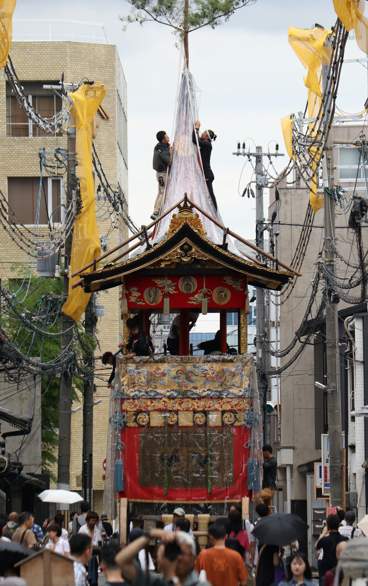 节日花车在街道上行驶，周围人群熙熙攘攘