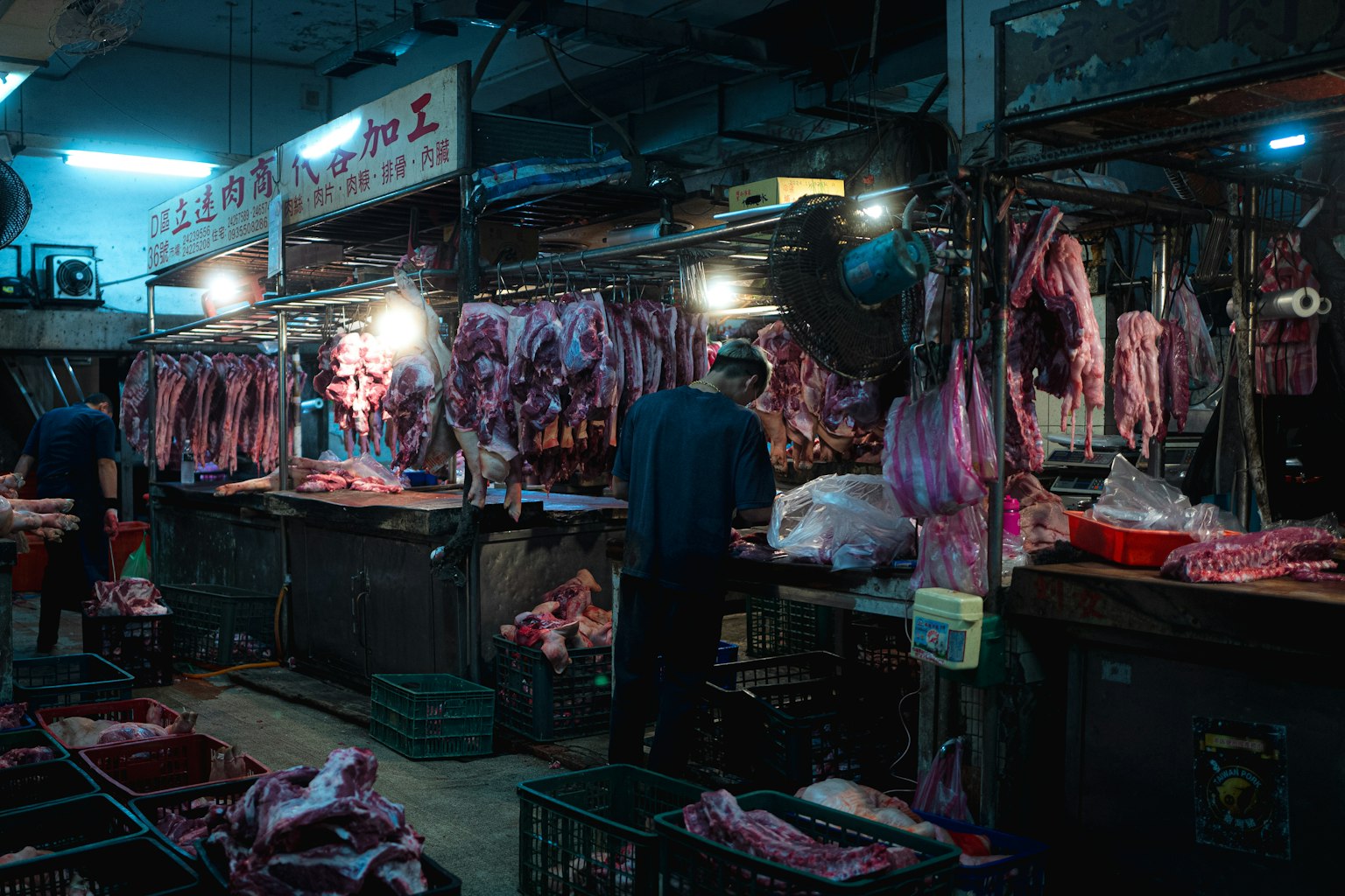Scena di mercato di macelleria con carne appesa e un venditore