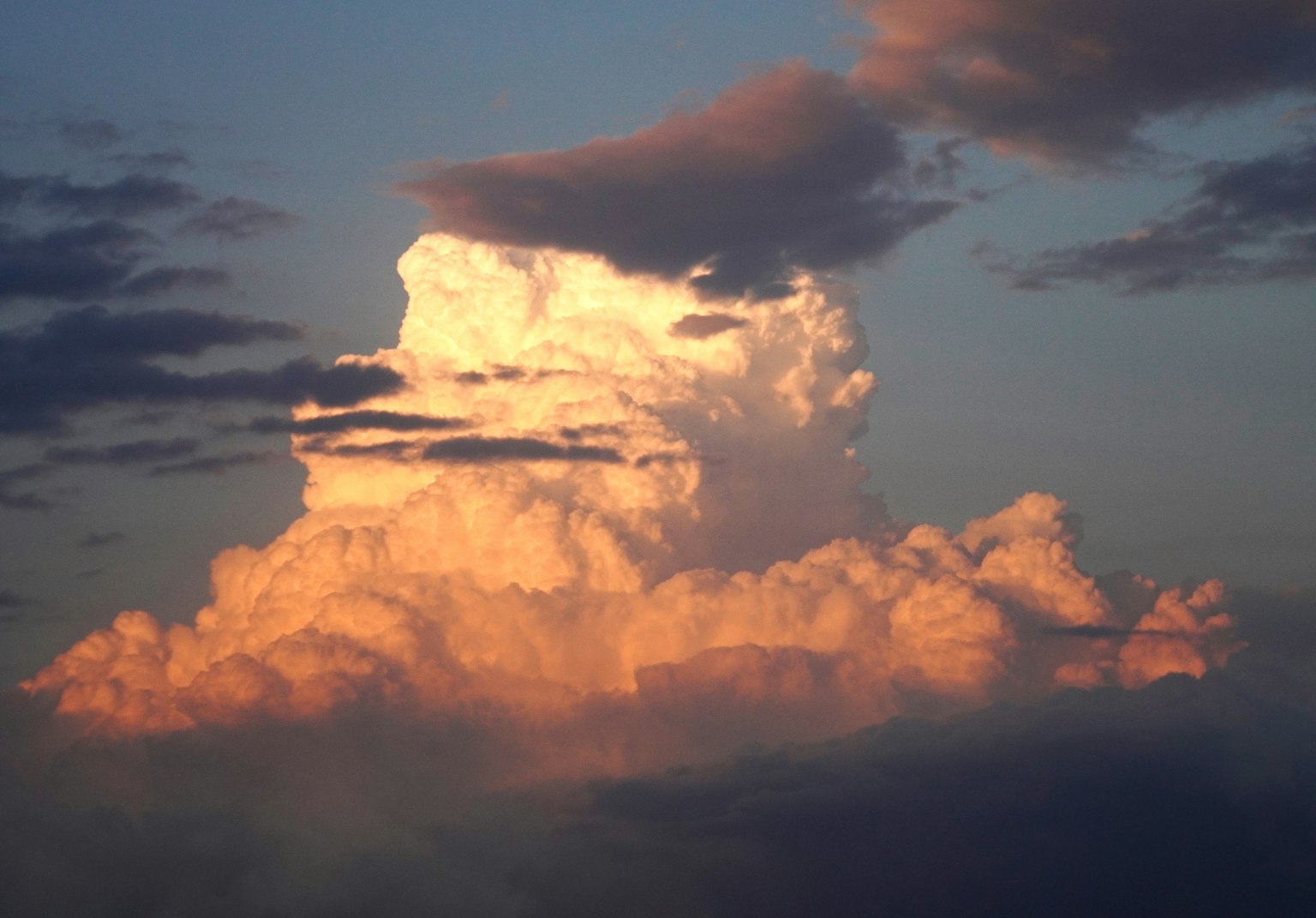 Un grand nuage cumulonimbus illuminé par les couleurs du coucher de soleil dans le ciel