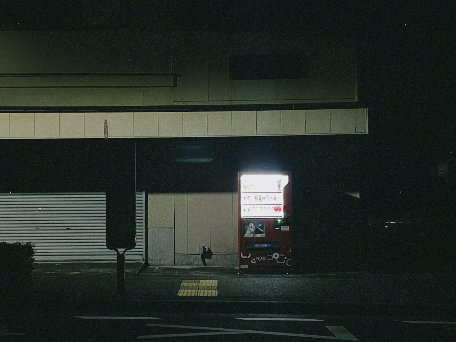 Illuminated red vending machine on a dark street