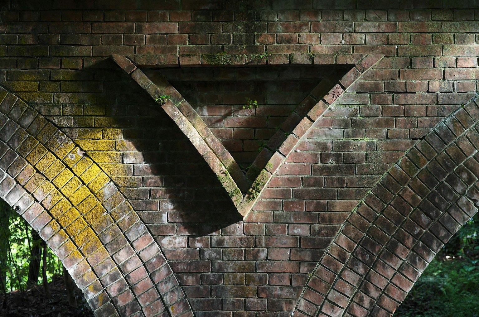 Dreieckiger Relief an einem Ziegelbogen im natürlichen Licht