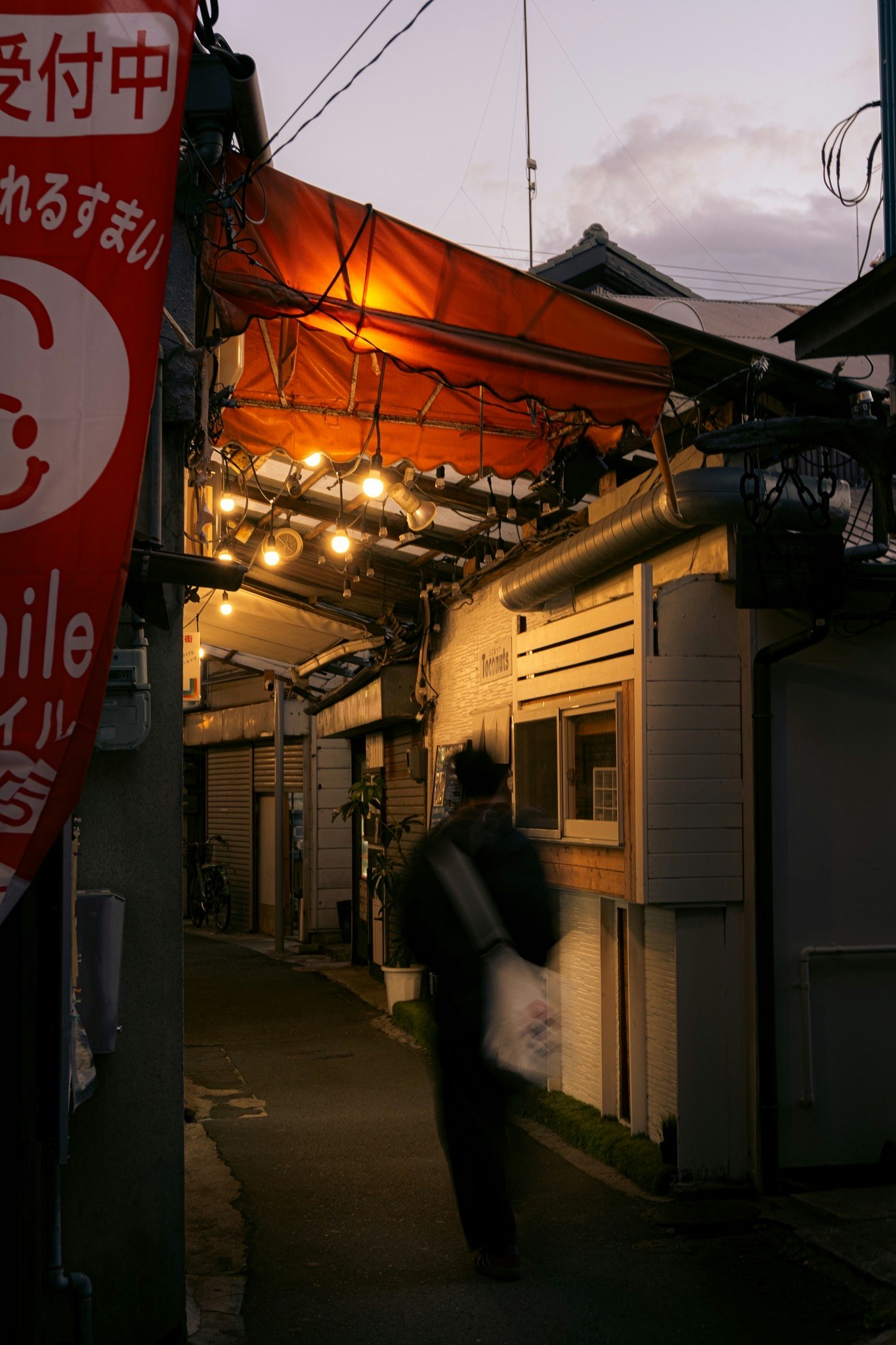 alley in a shopping street with hanging lanterns and streetlights
