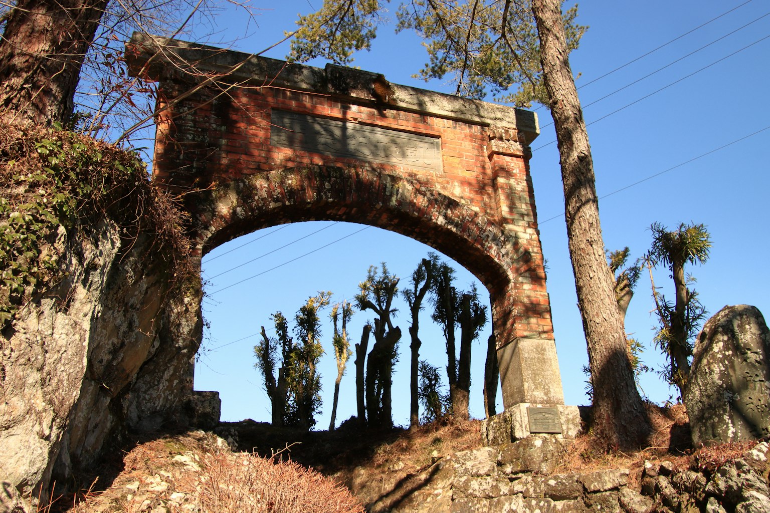 Antica struttura ad arco con alberi circostanti