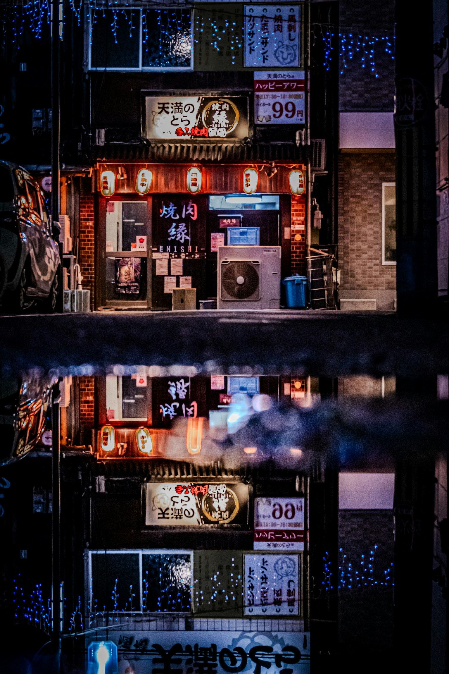 Riflessi di un ristorante vivace con luci al neon in una pozzanghera di notte