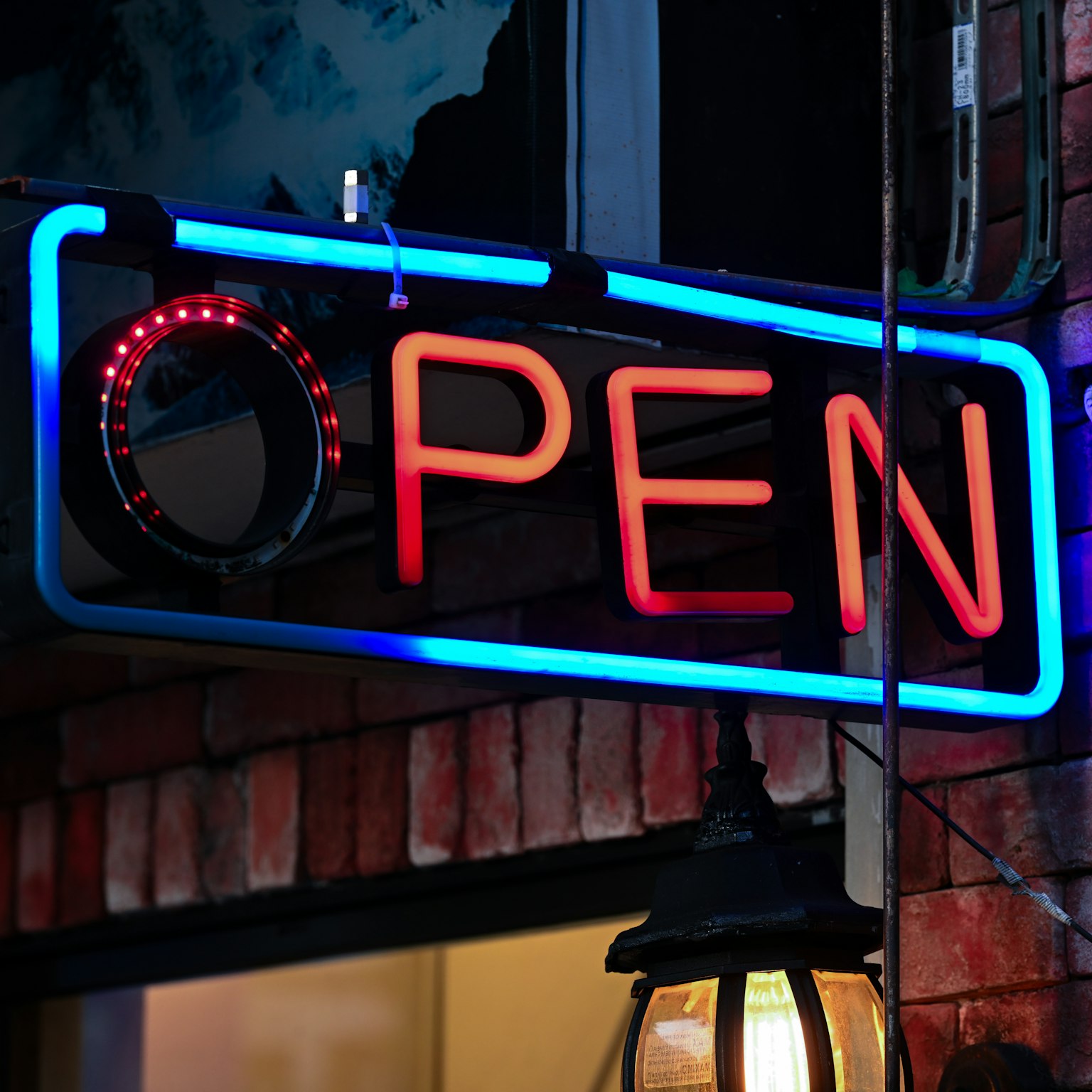 Một biển hiệu neon sáng với chữ OPEN màu xanh và đỏ