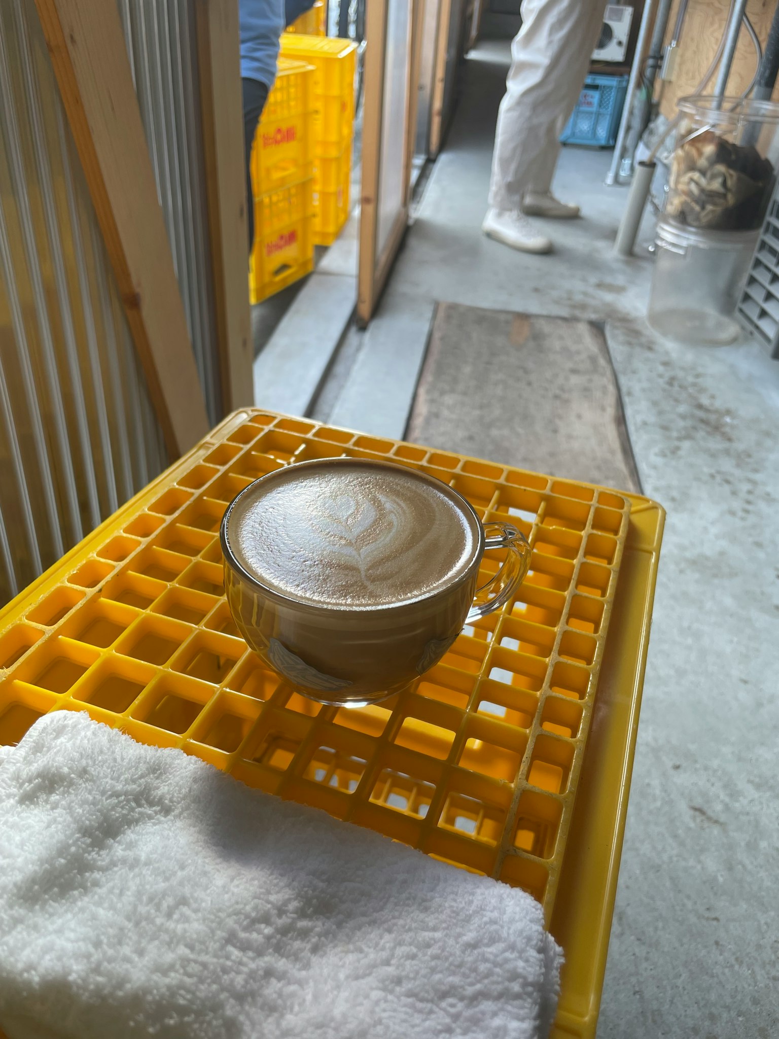 工作空间内黄色塑料架上的咖啡杯和毛巾