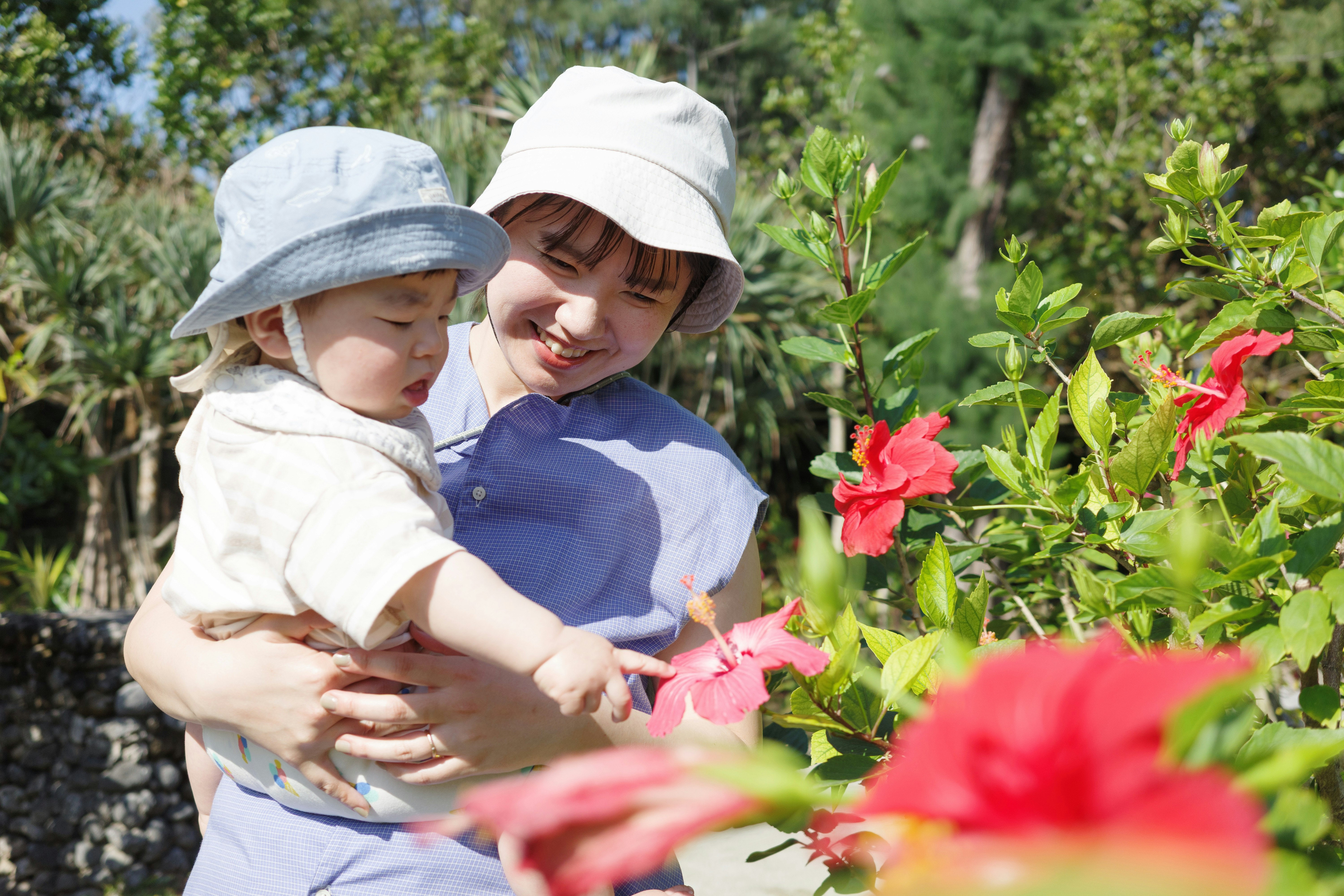 cha mẹ bế con trong vườn hoa