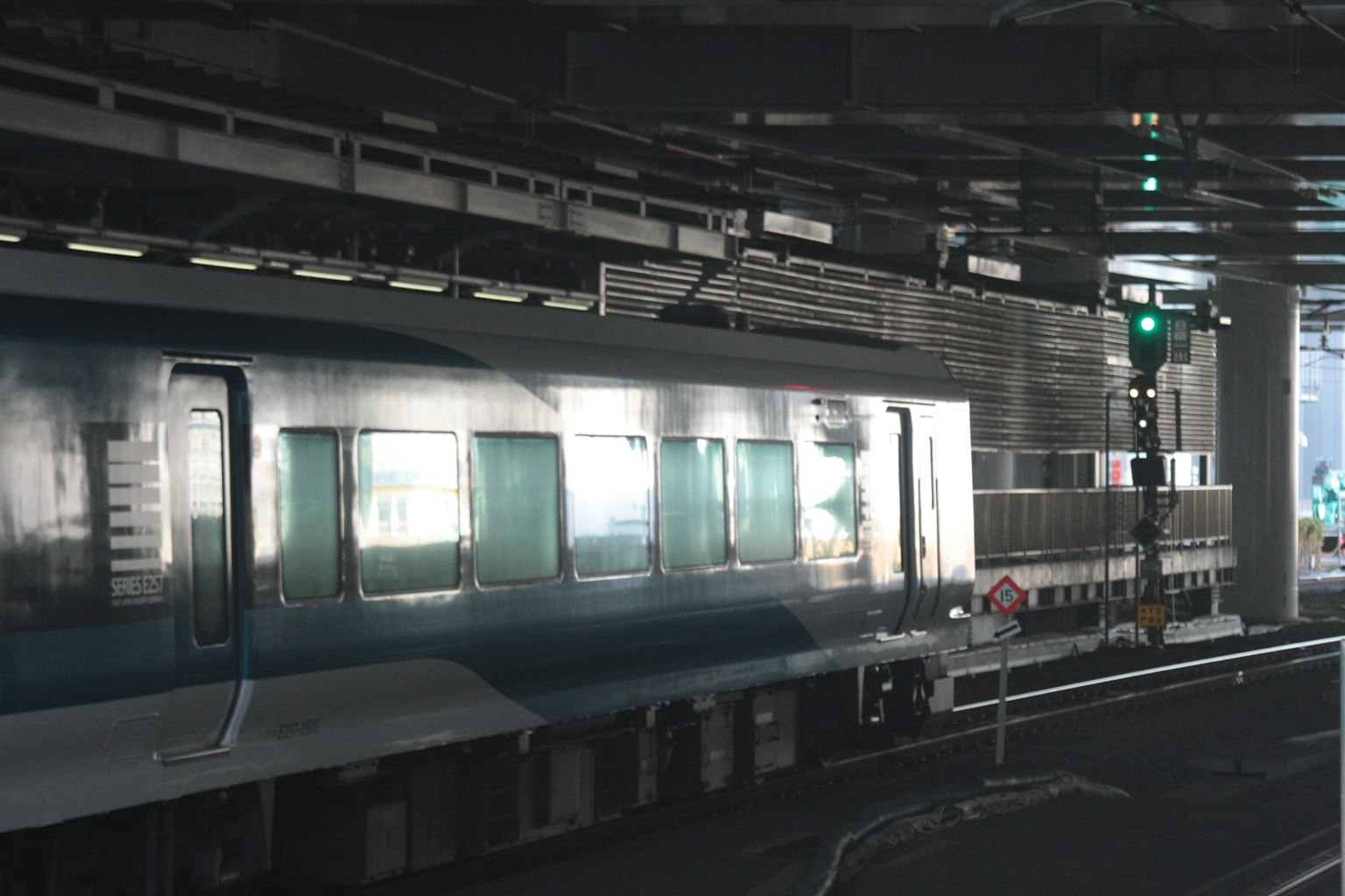 Train garé sur un quai de gare avec un signal vert