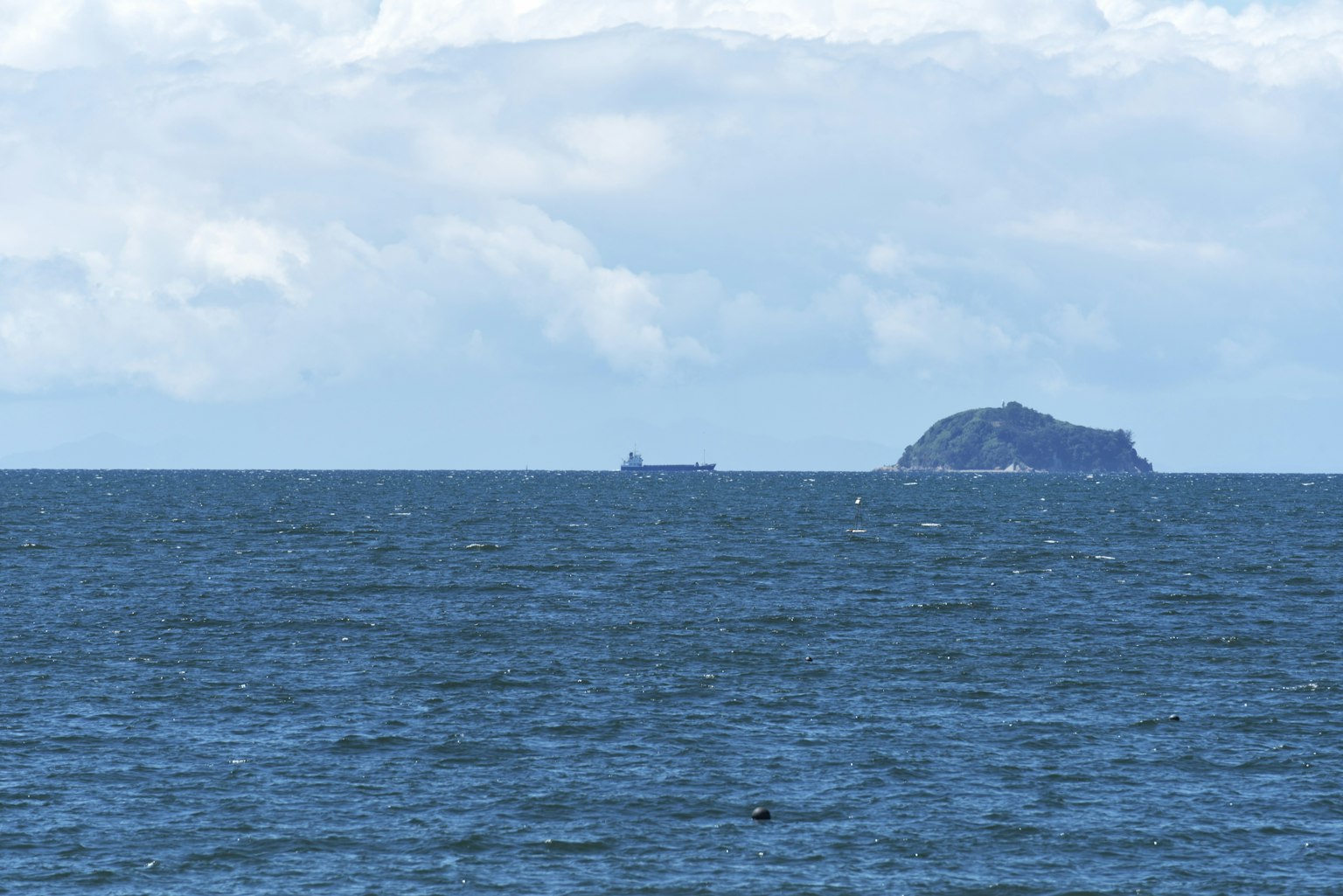 เกาะในมหาสมุทรและเรือที่อยู่ไกลออกไป