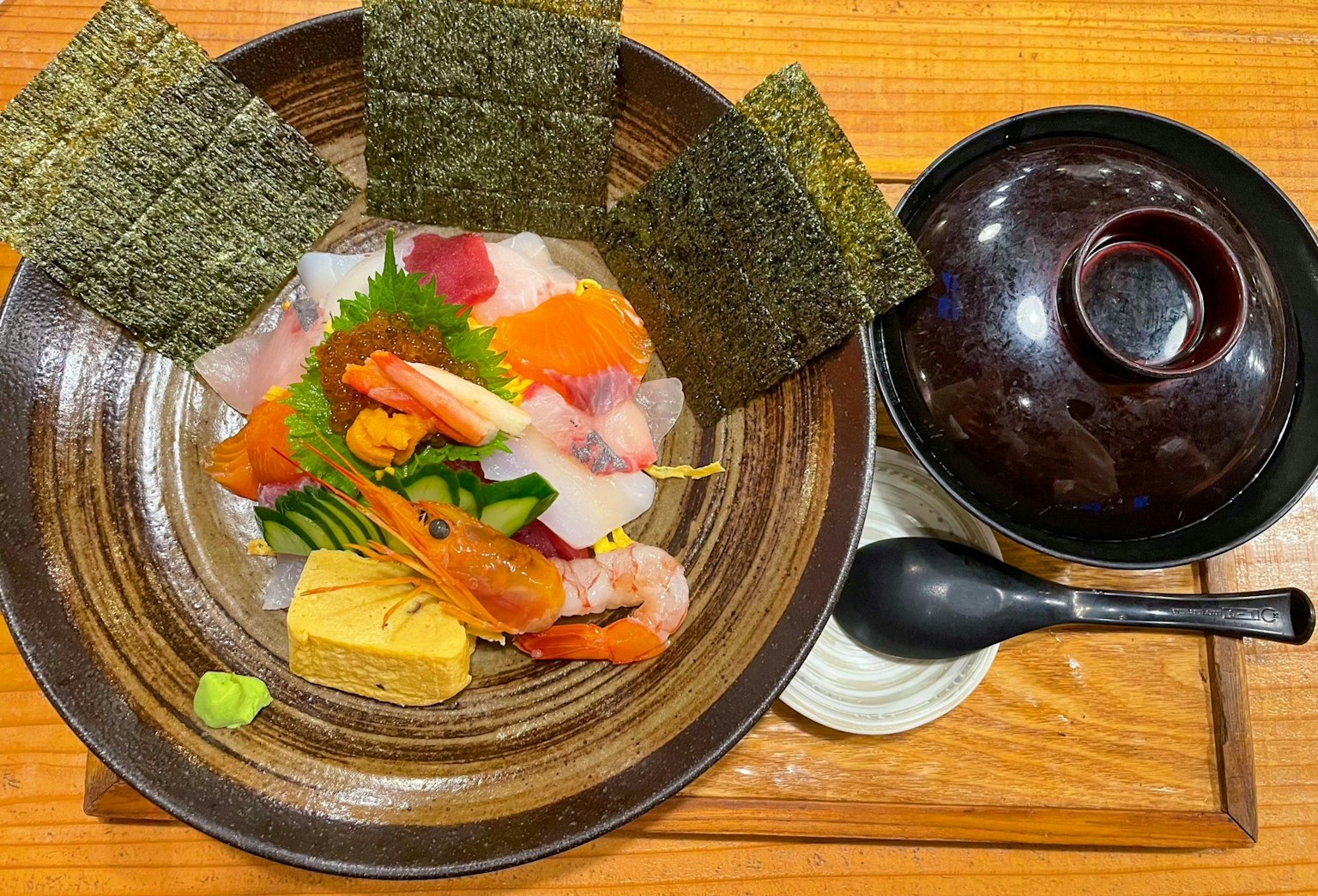 Ein Teller mit frischem Sashimi und Tamagoyaki mit Miso-Suppe daneben