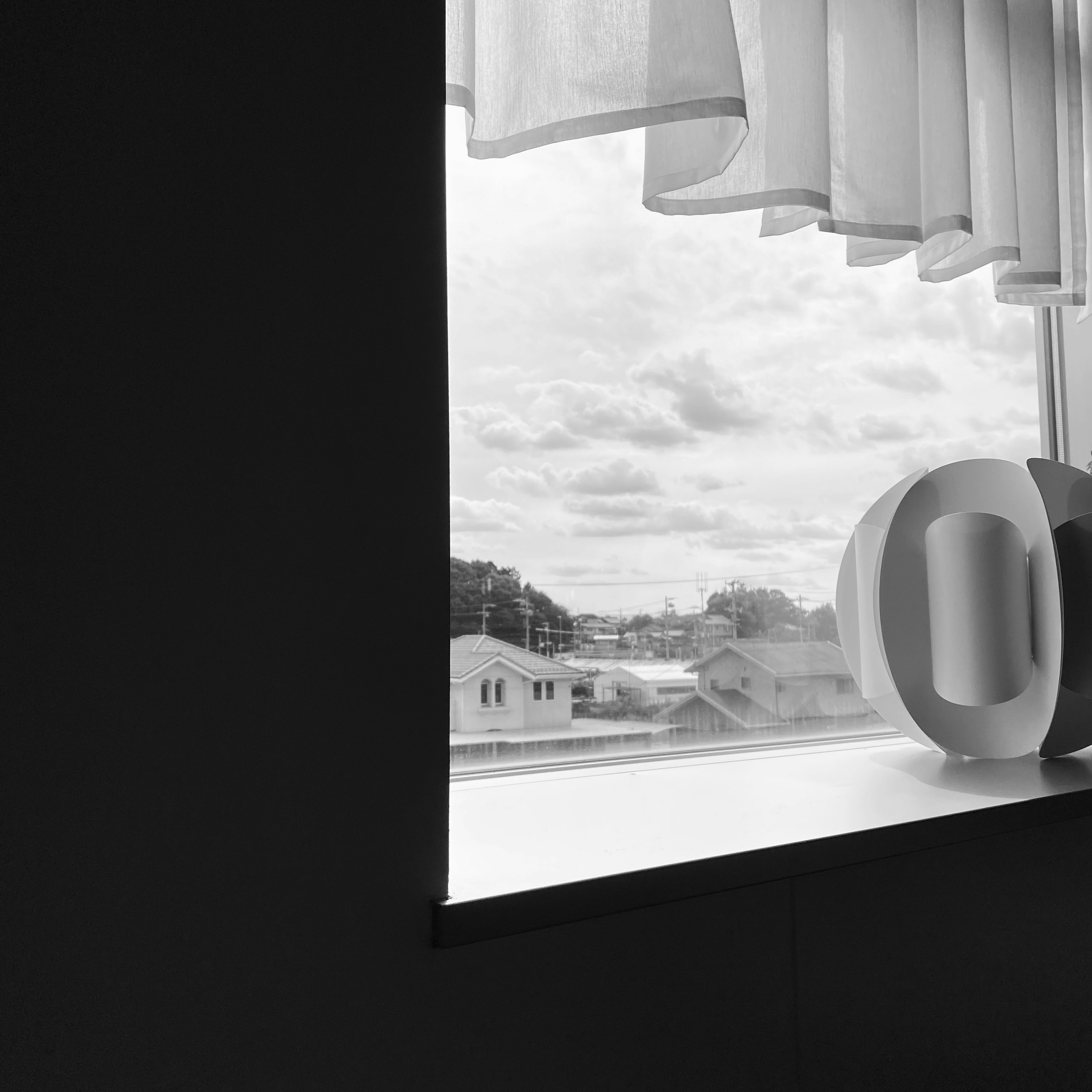 vista de casas suburbanas y cielo nublado desde una ventana