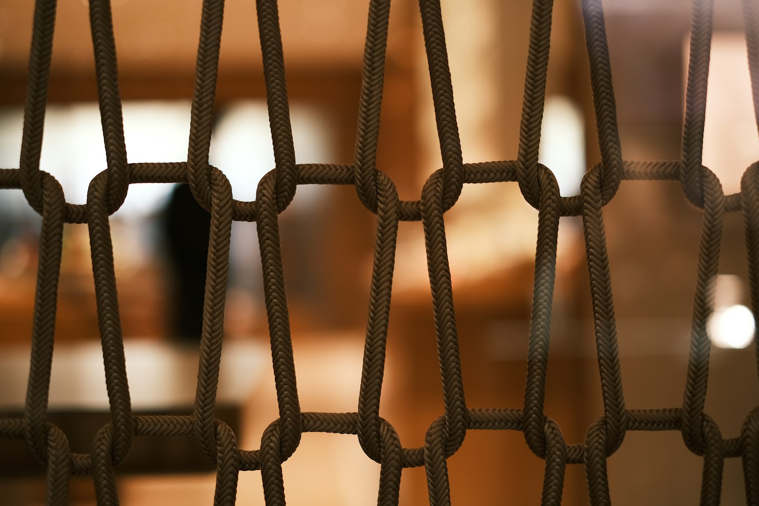 Image featuring a distinctive metal mesh pattern with a blurred brown background