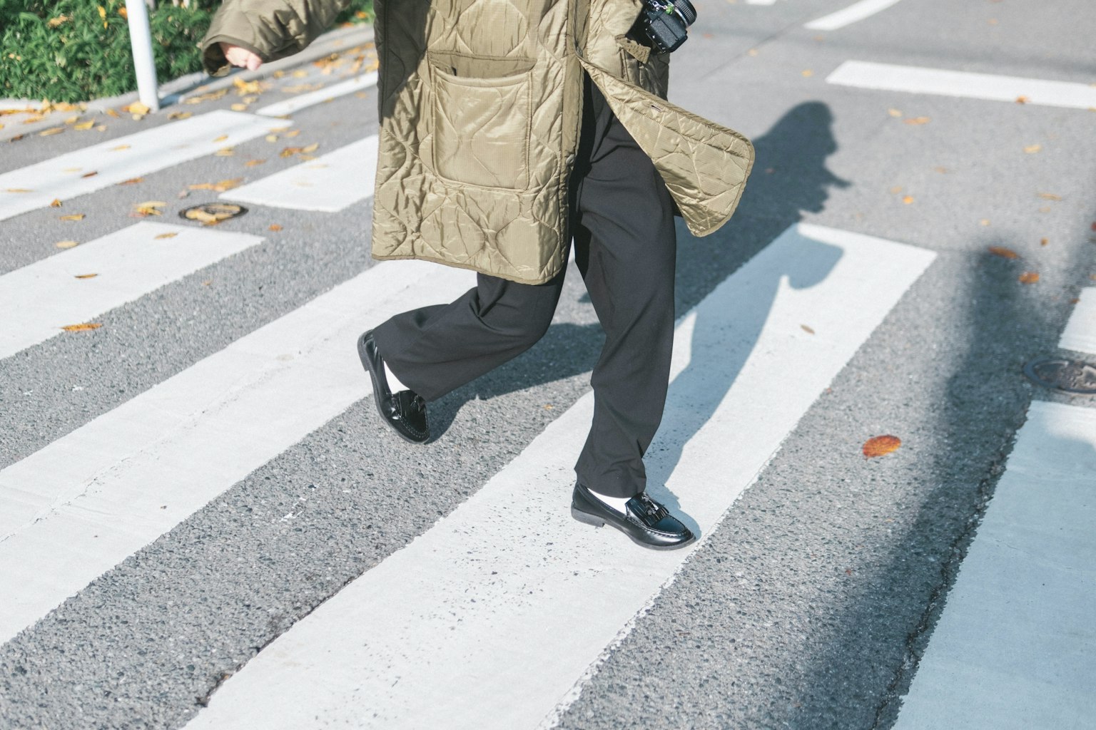 횡단보도에서 걷는 사람의 발과 그림자