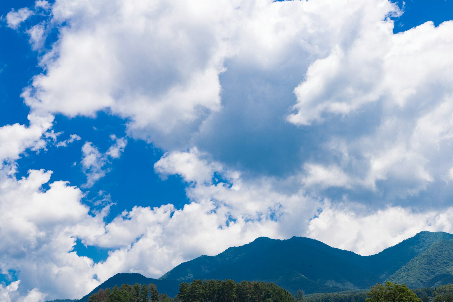 Mountain landscape surrounded by blue sky and white clouds