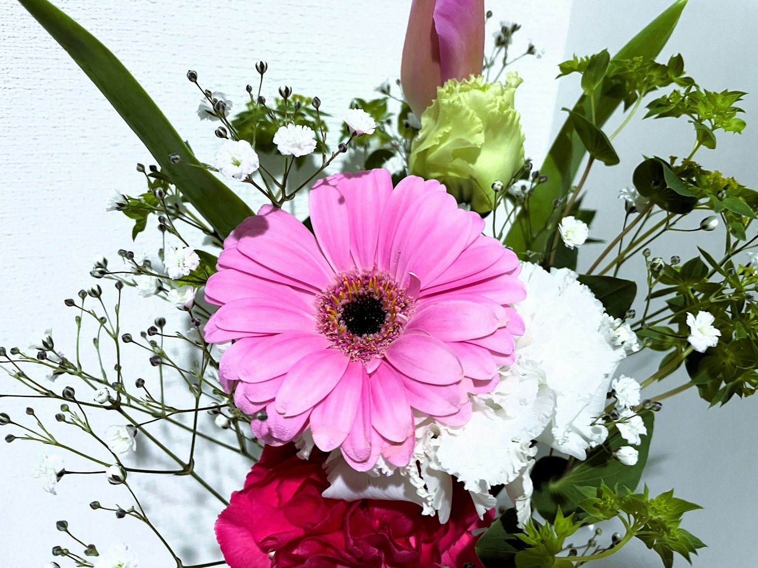 Ramo con una margarita rosa flores blancas y hojas verdes