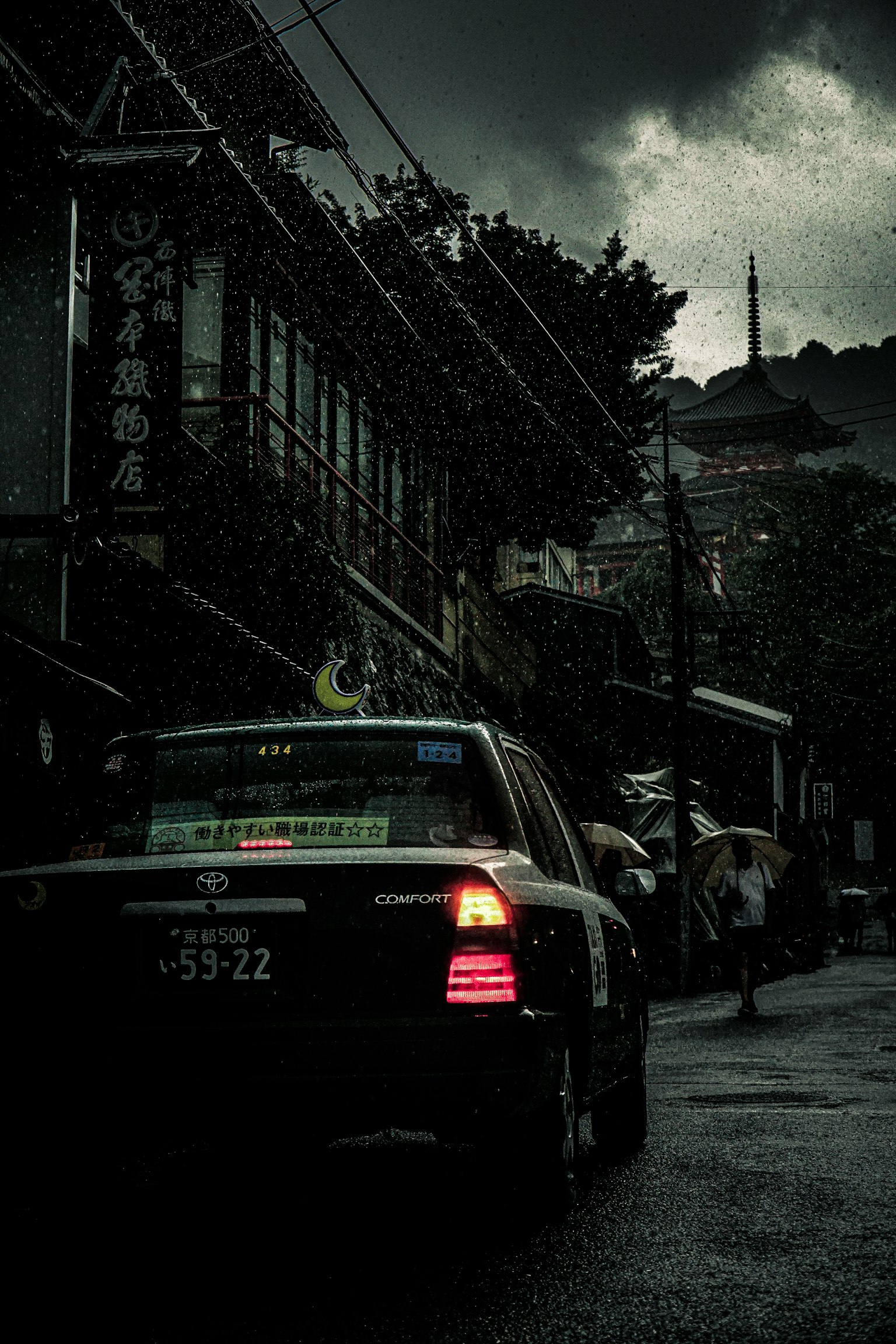 一輛停在陰暗天空下的計程車，街道被雨水浸濕