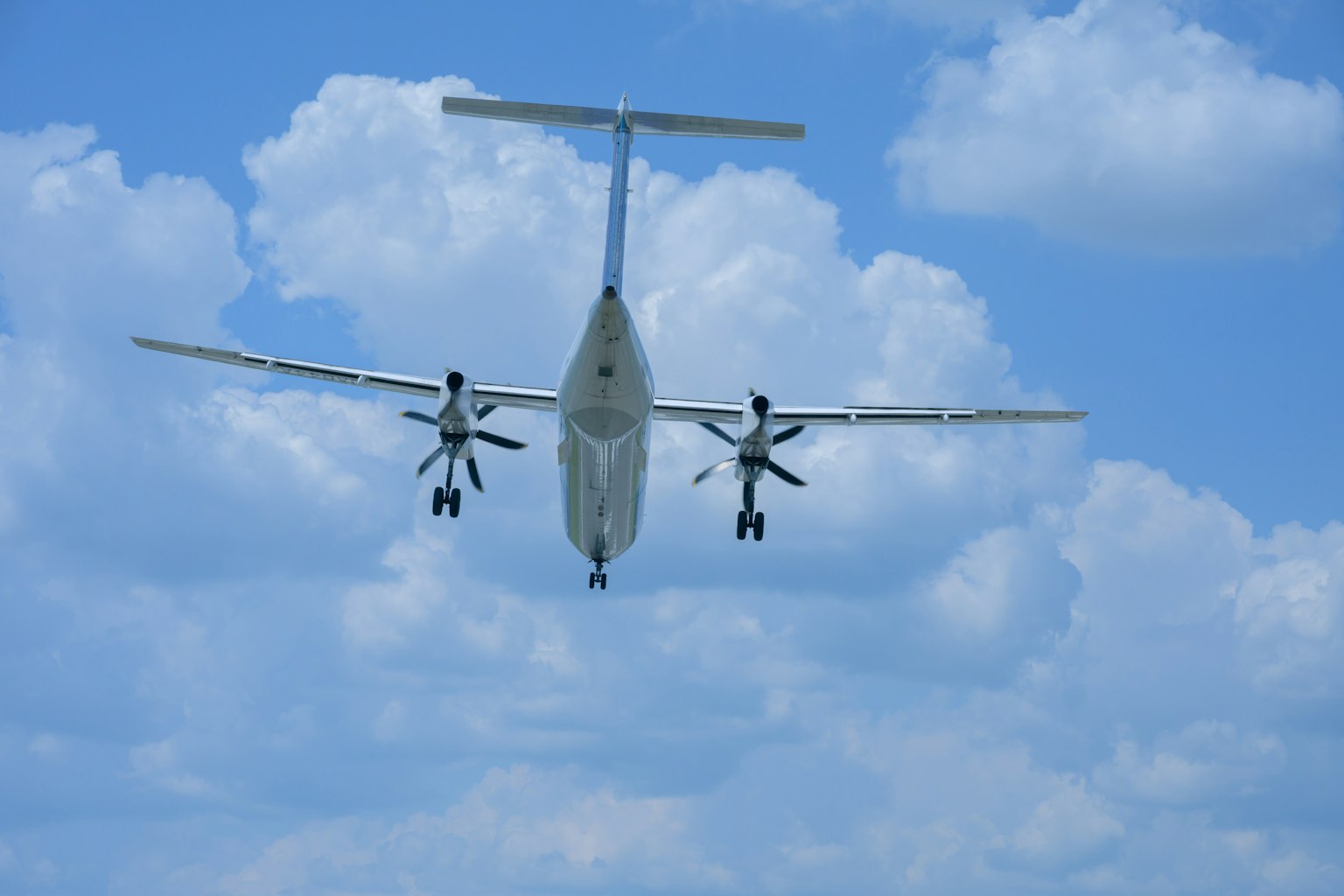 Pesawat propeller bermesin ganda terbang di langit biru