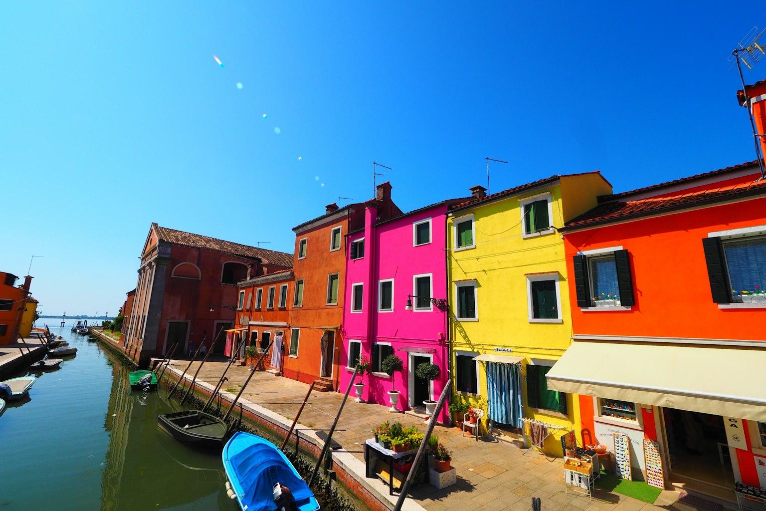 Case colorate lungo un canale sotto un sole splendente