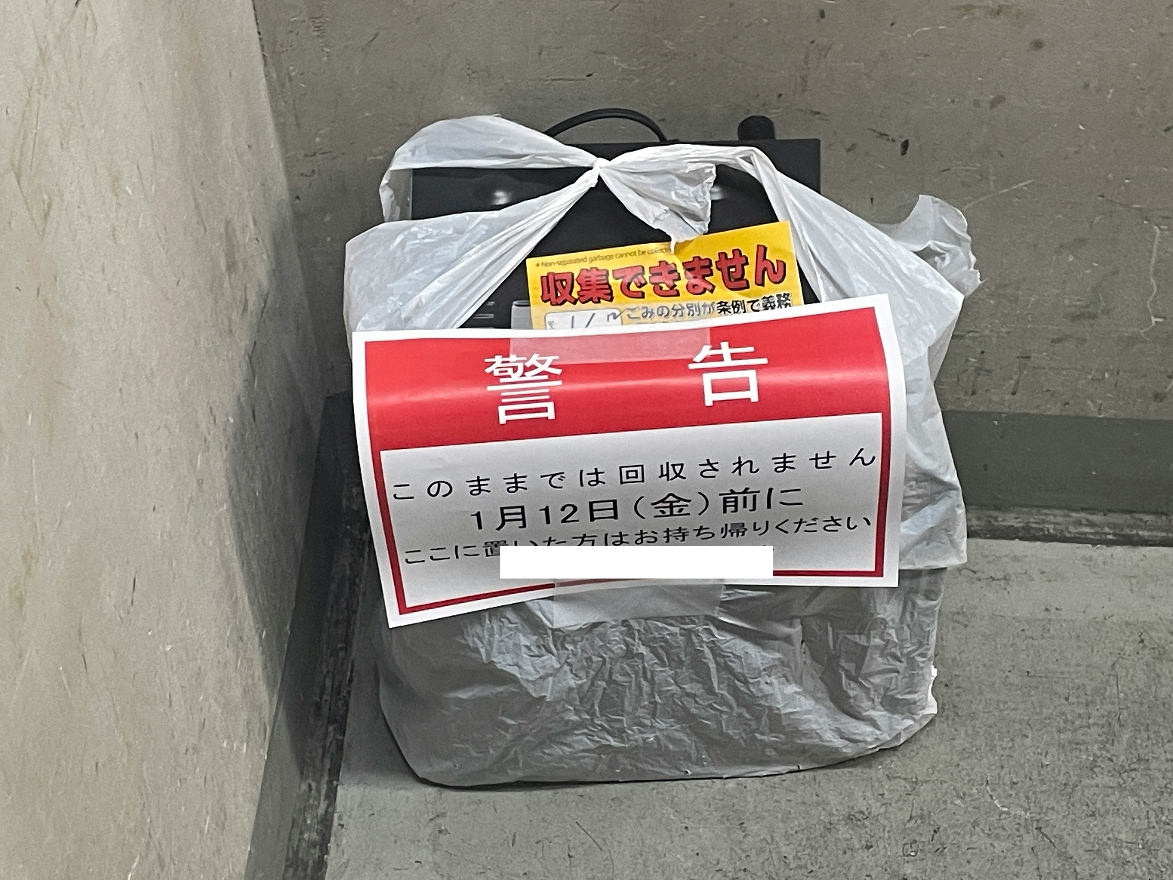 混凝土地面上帶警示標示的回收袋